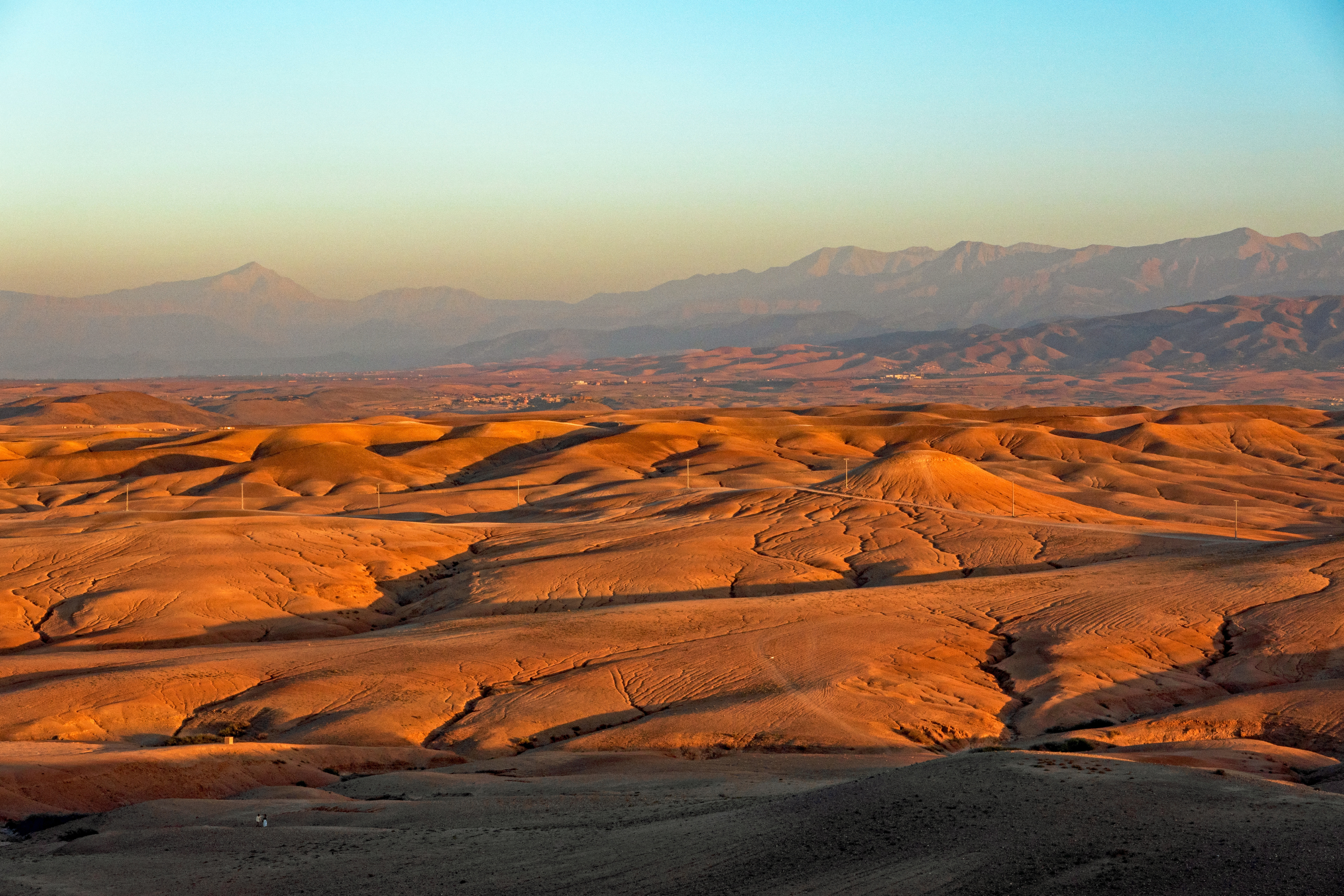 Golden rolling hills with the Atlas Mountains at sunset in Morocco