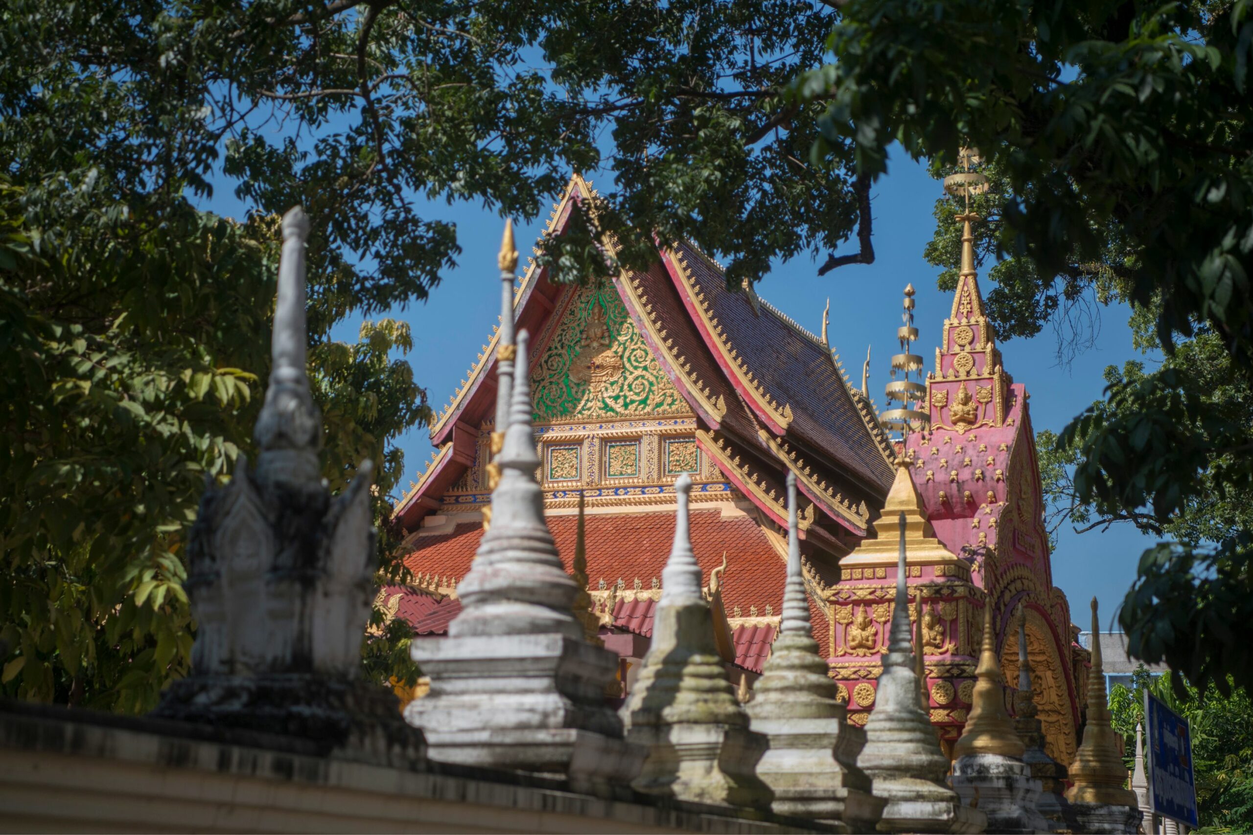 Ornate Buddhist temple roof and stupas at a Vientiane wat, Laos