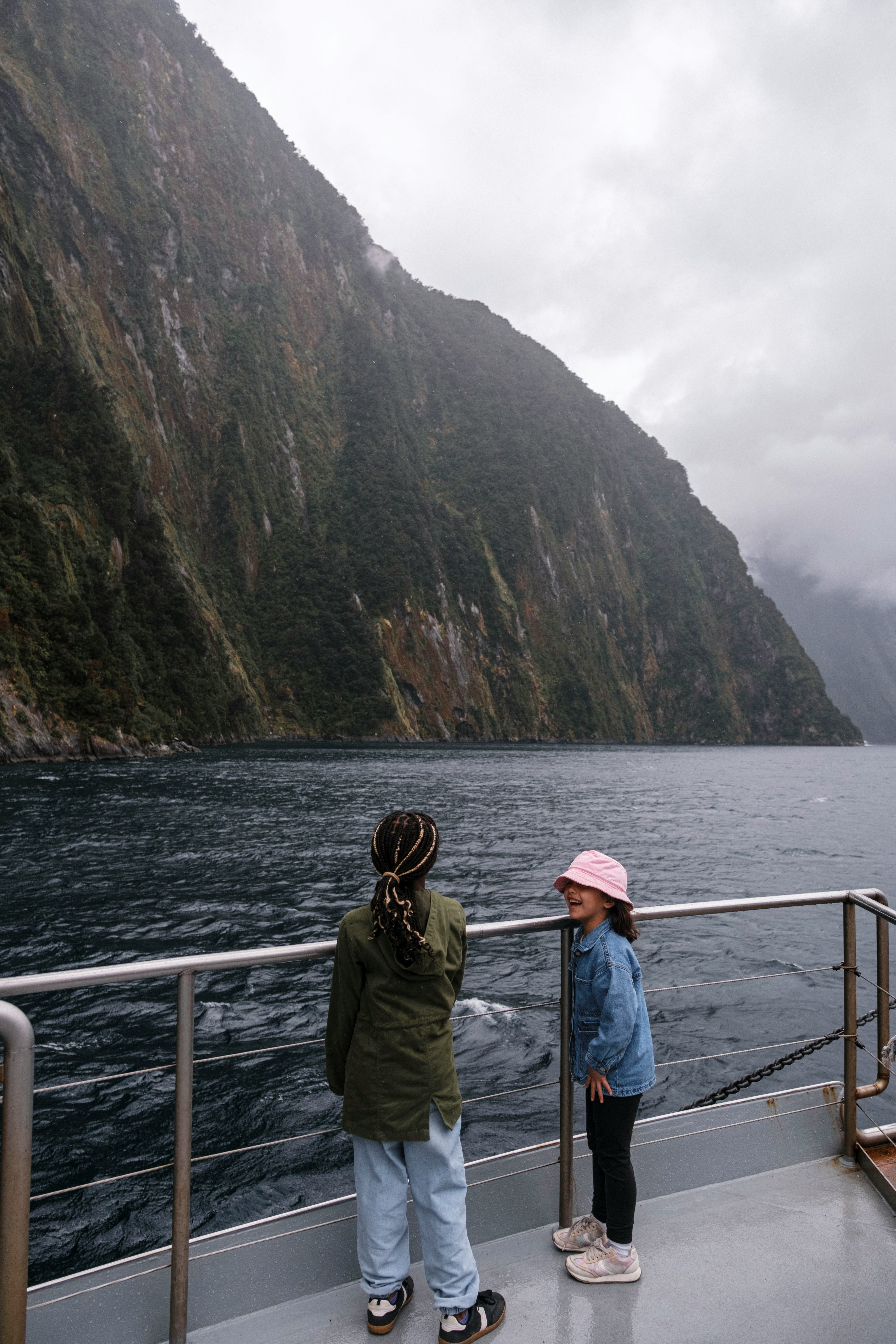 Children on a boat cruising through Milford Sound, Fiordland, New Zealand