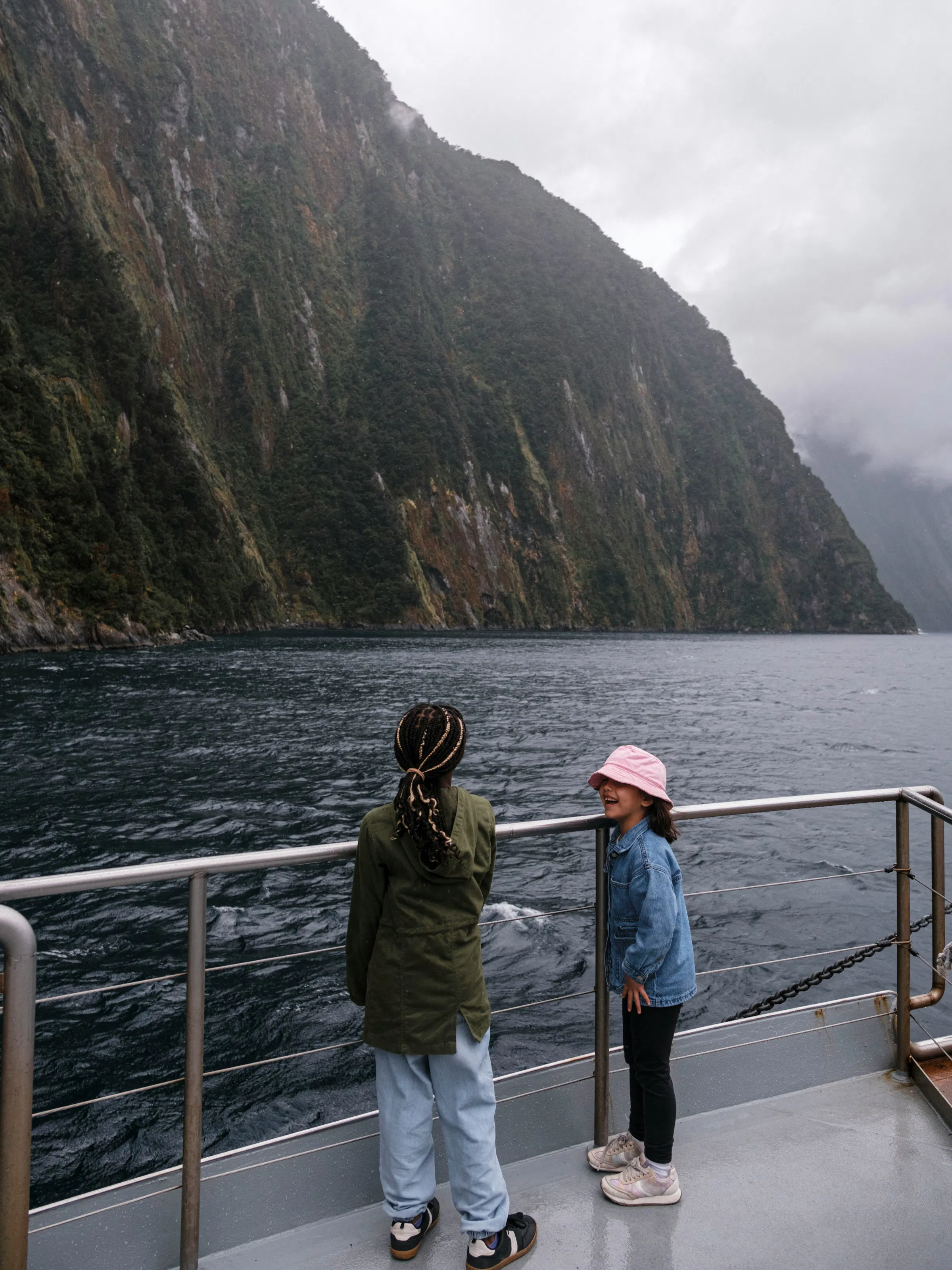 Children on a boat cruising through Milford Sound, Fiordland, New Zealand