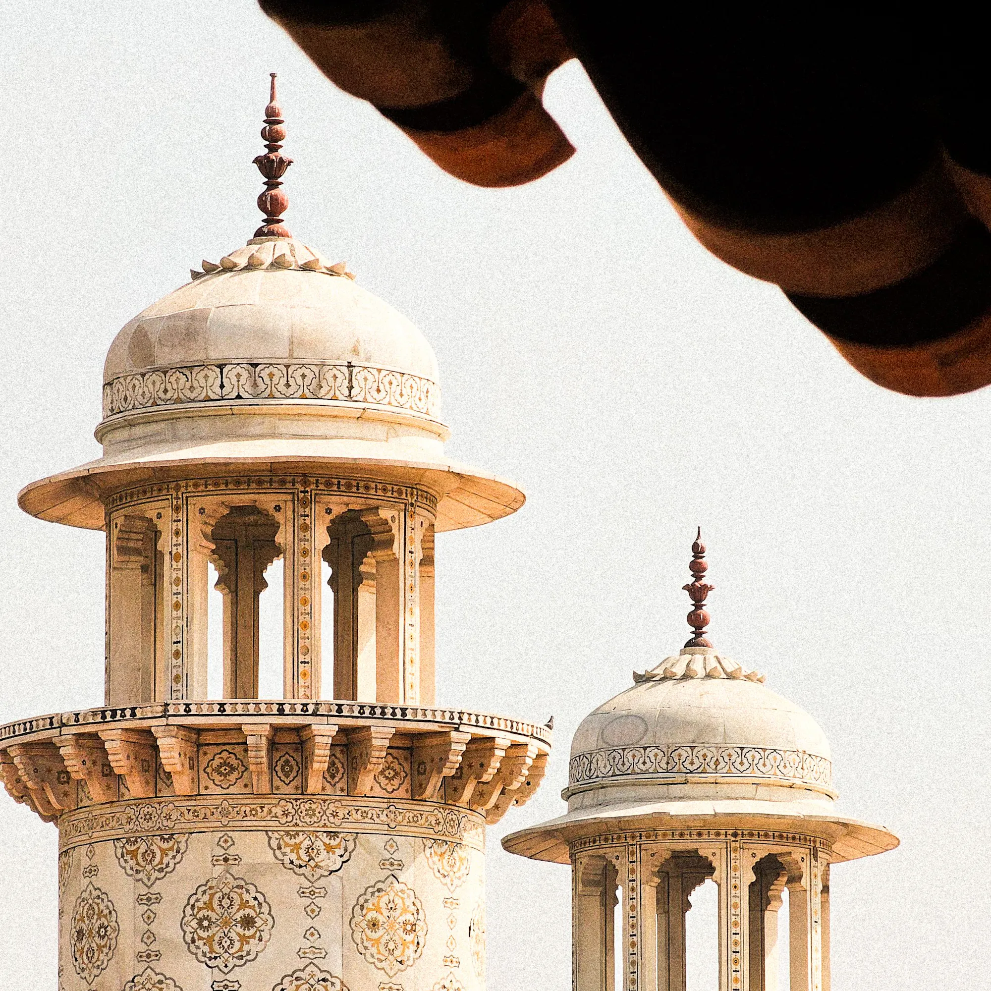 Close-up of ornate marble minaret domes with intricate inlay patterns at the Taj Mahal, Agra