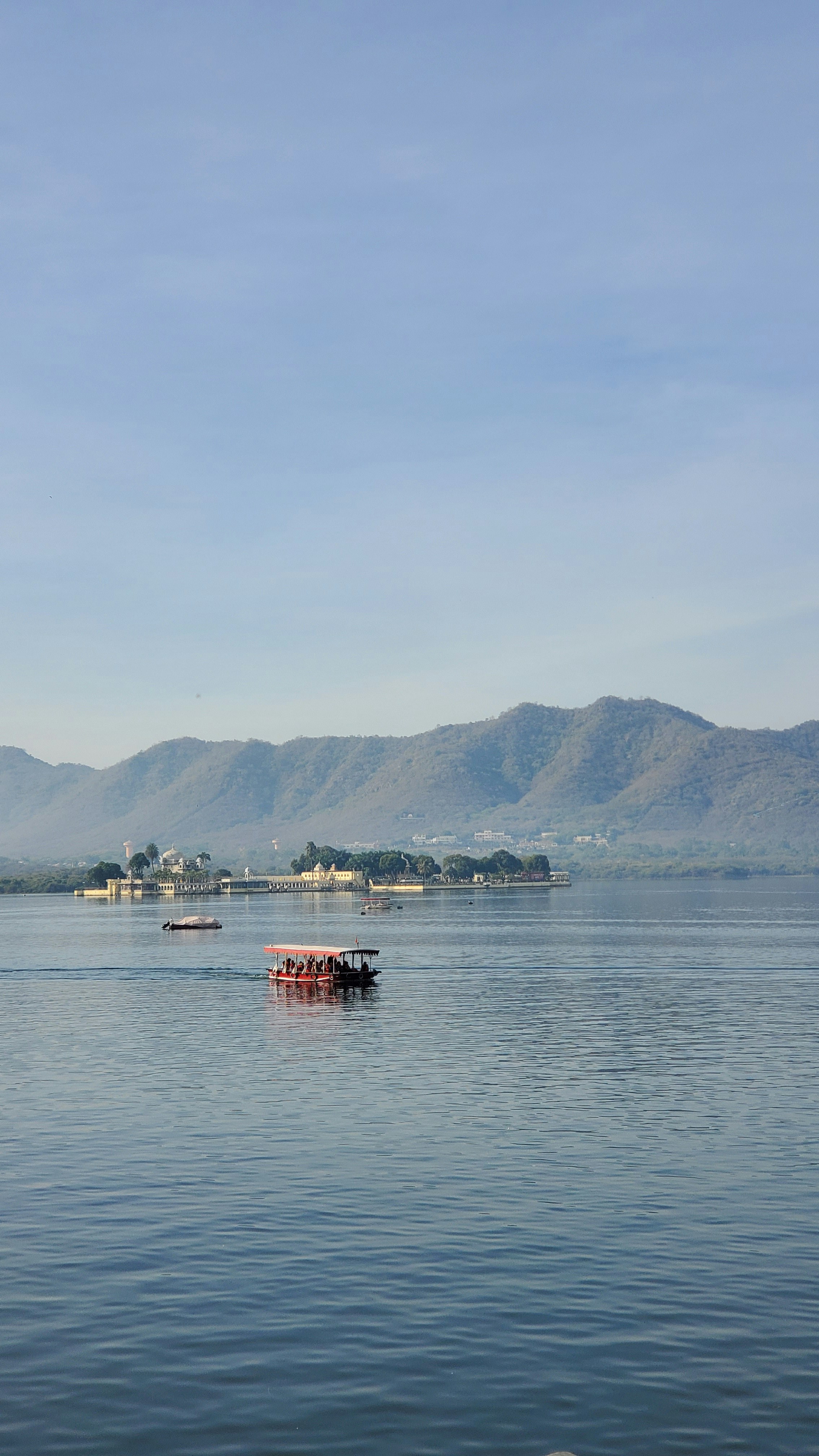 Tourist boat on Lake Pichola with Jagmandir Island Palace, Udaipur