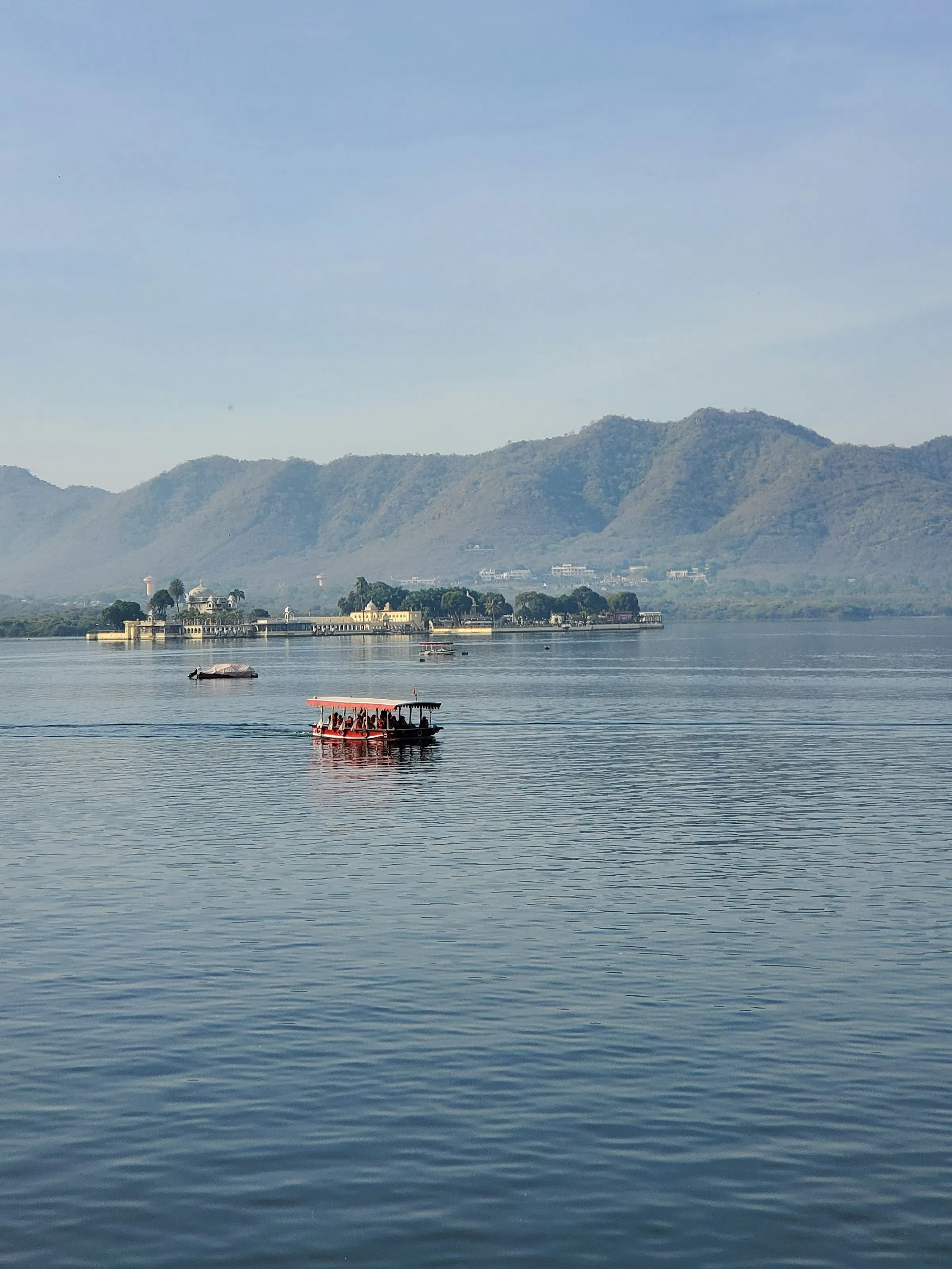 Tourist boat on Lake Pichola with Jagmandir Island Palace, Udaipur