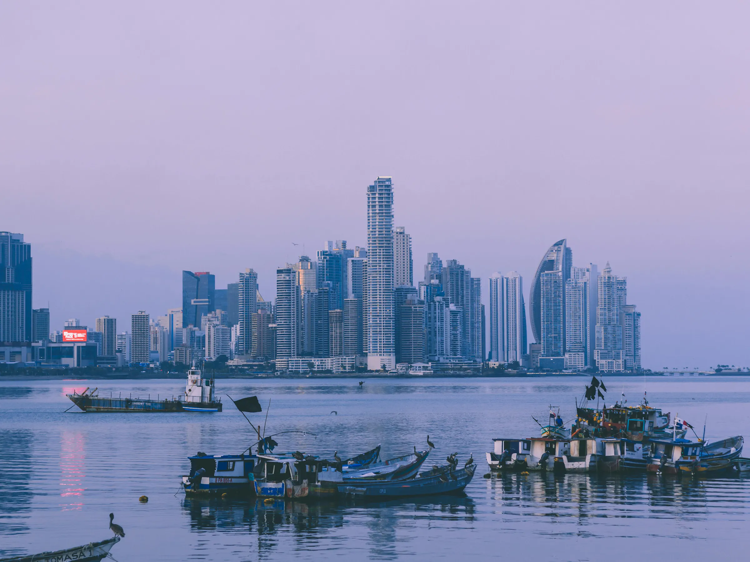 Panama City skyline at dusk with fishing boats in the foreground