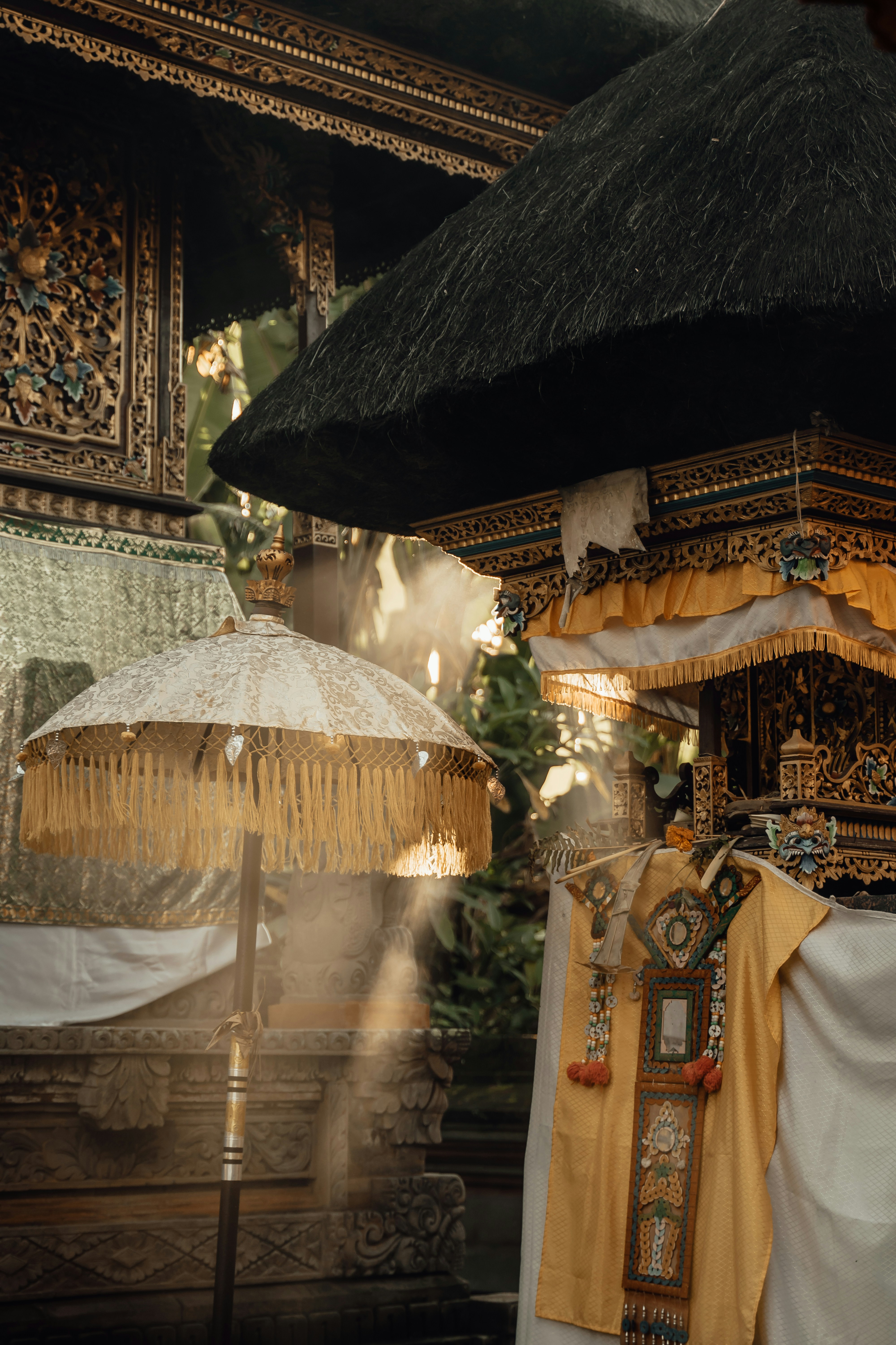 Traditional Balinese ceremonial umbrella and gilded temple shrine decorations, Indonesia