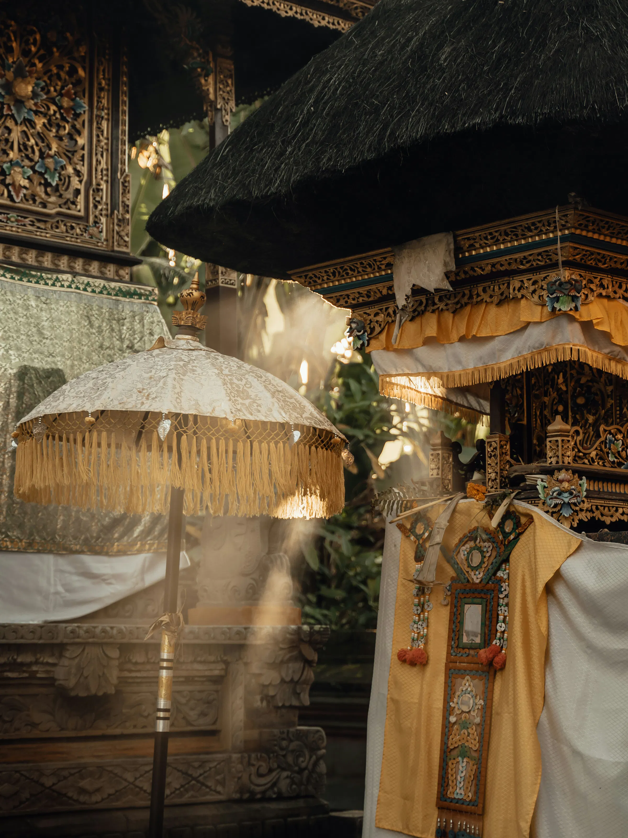 Traditional Balinese ceremonial umbrella and gilded temple shrine decorations, Indonesia