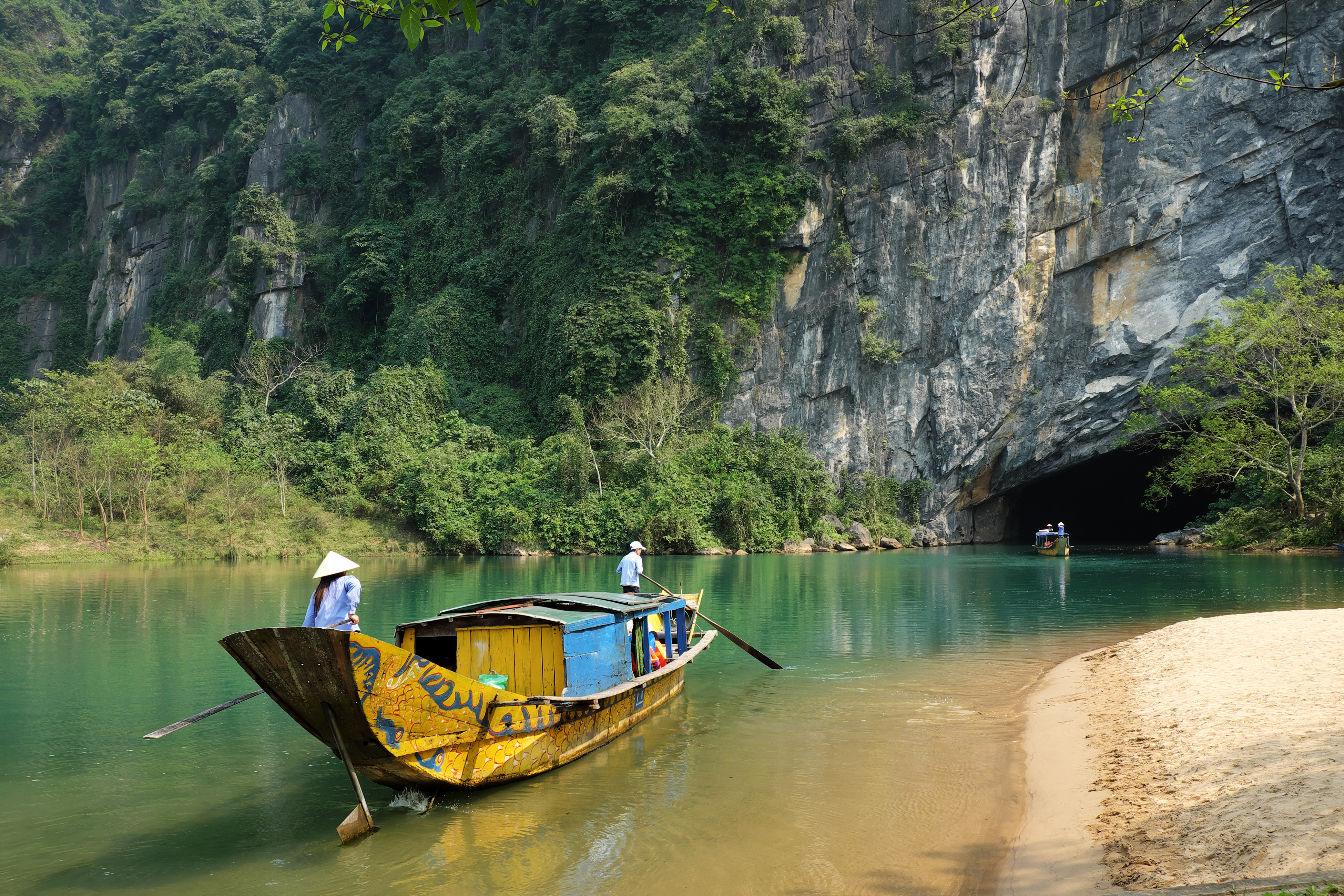 Colorful wooden boat entering Phong Nha cave, Vietnam