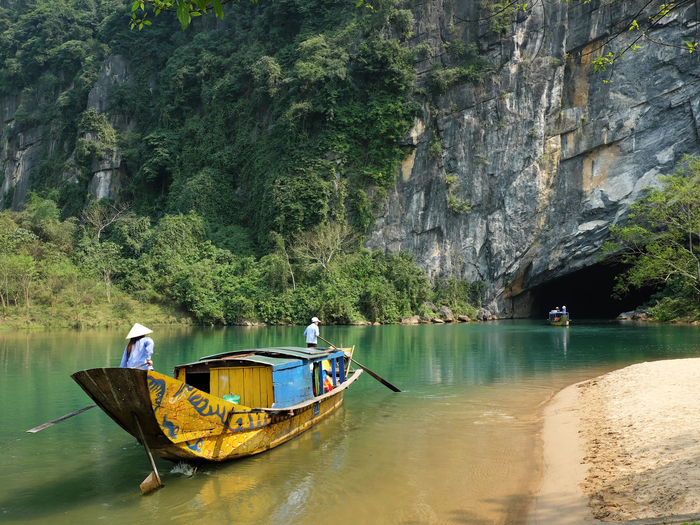 Colorful wooden boat entering Phong Nha cave, Vietnam