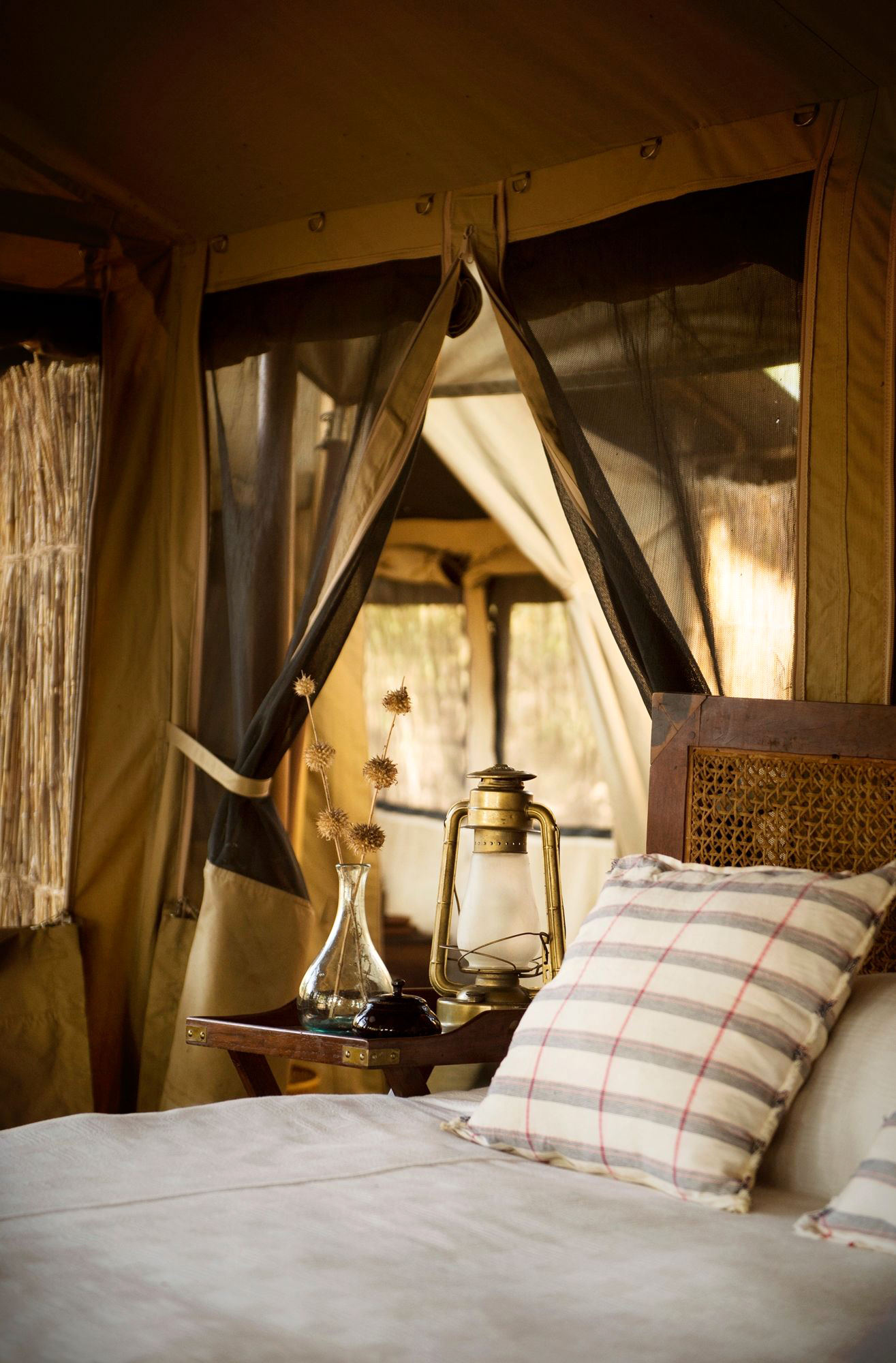 Rustic luxury safari tent interior with brass lantern, Tanzania