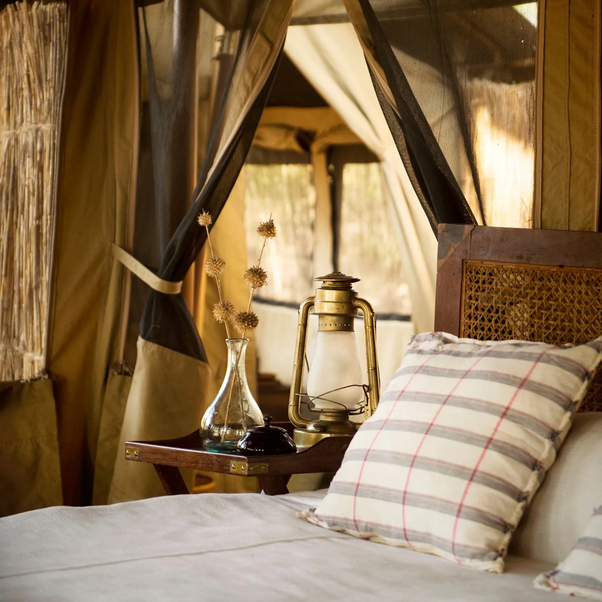 Rustic luxury safari tent interior with brass lantern, Tanzania
