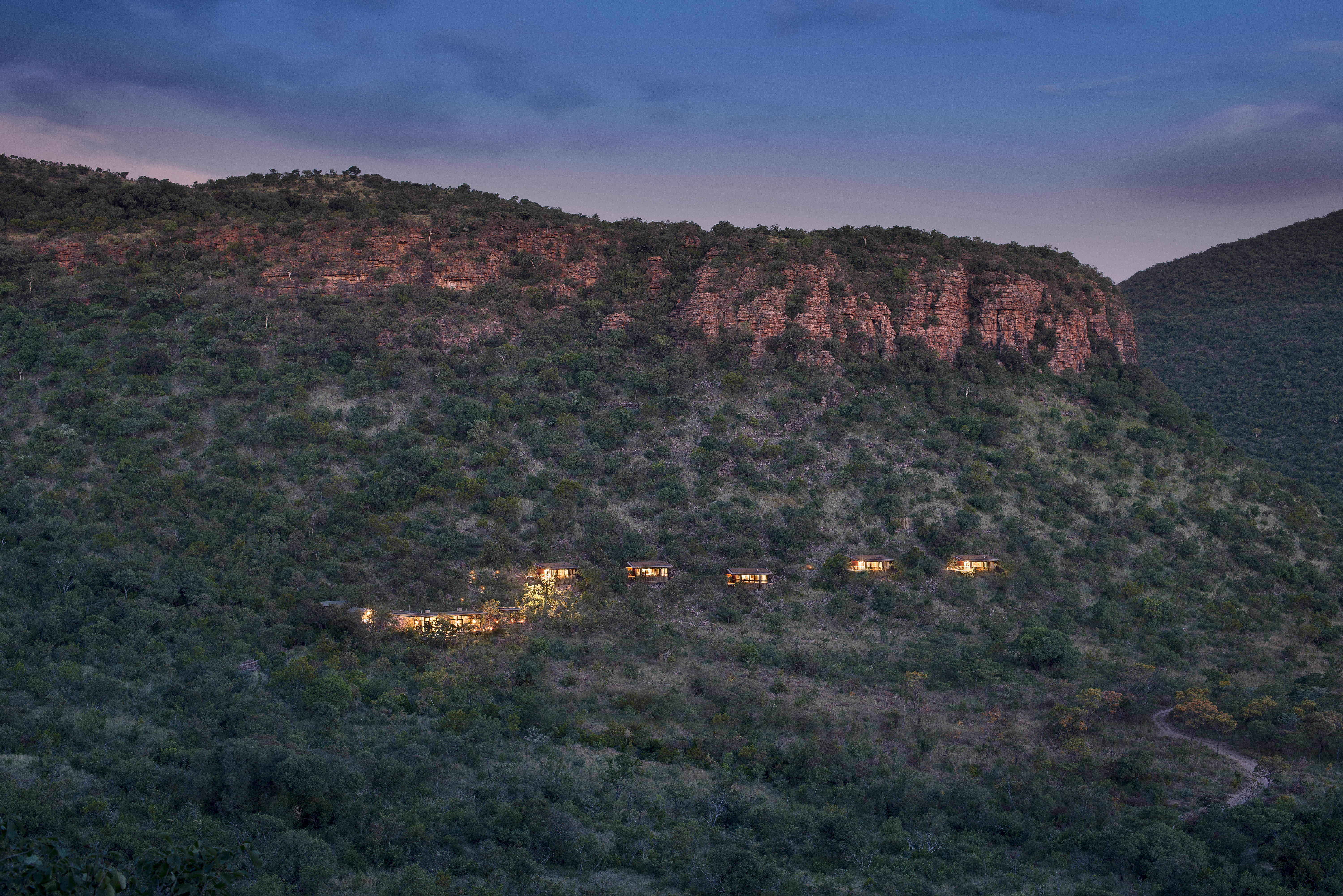 Marataba Walking Trails Lodge chalets illuminated at dusk in the Waterberg mountains, South Africa