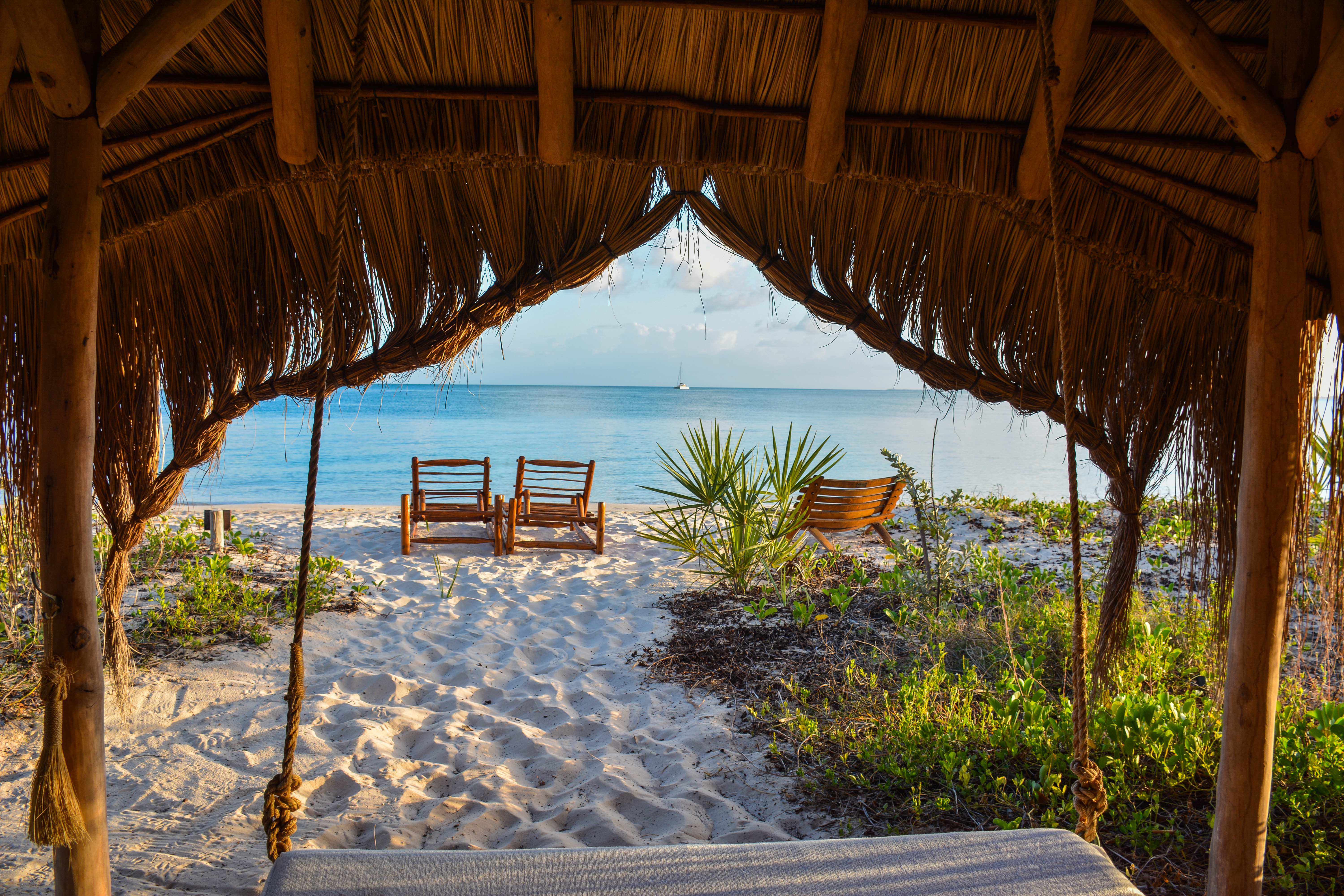 Thatched beach gazebo with wooden chairs overlooking Indian Ocean