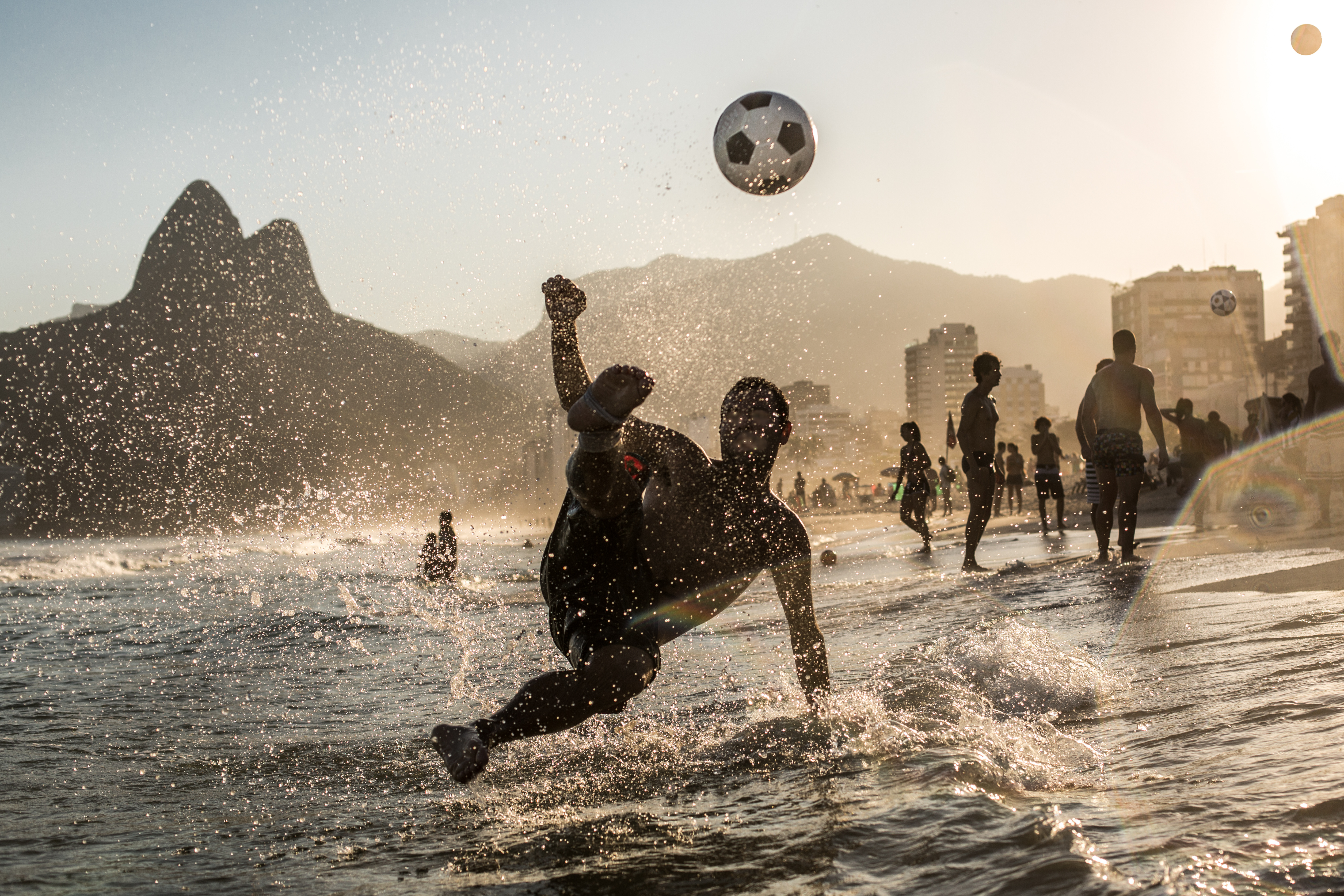 Player bicycle kick on Ipanema Beach with Dois Irmãos mountain, Rio de Janeiro Brazil