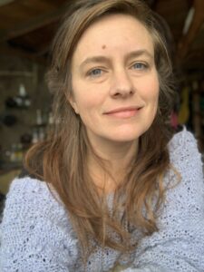 Portrait of Cathy Brown, travel writer for Extraordinary Journeys, wearing a soft knit sweater and looking into the camera in natural indoor light.