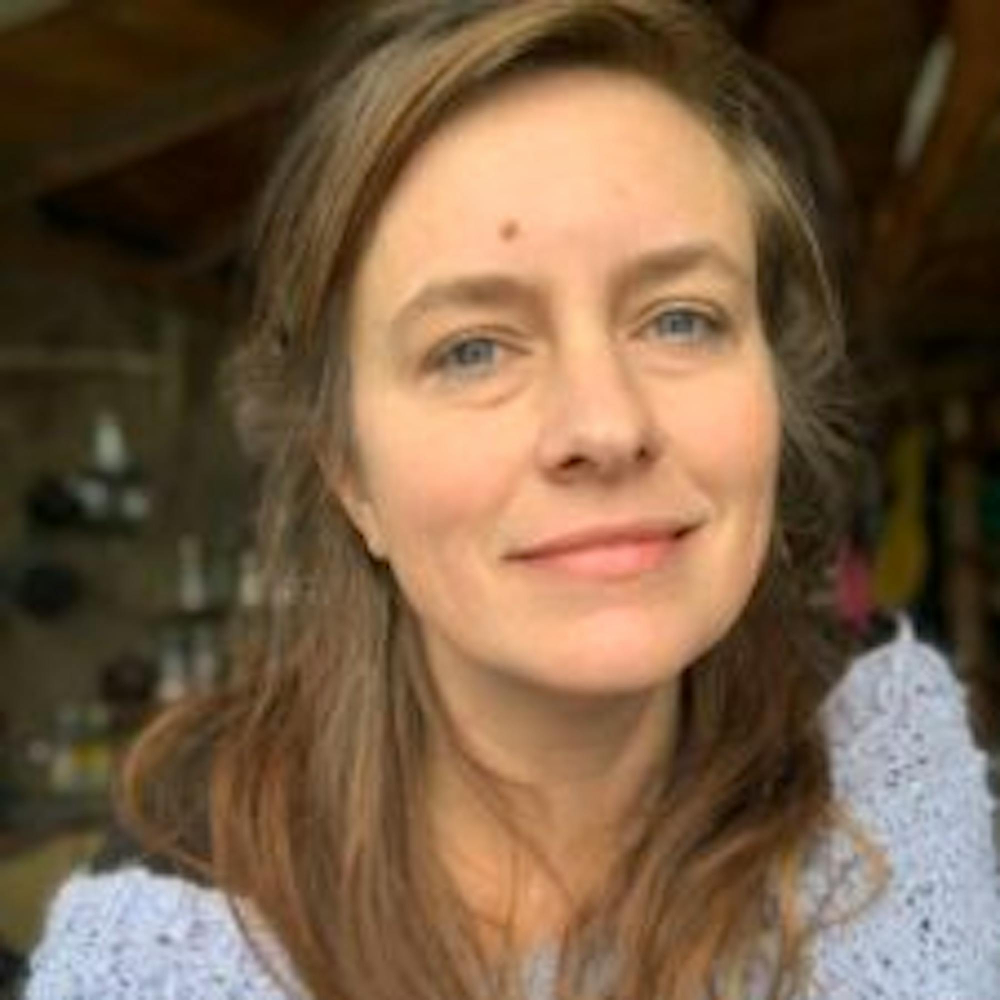 Portrait of Cathy Brown, travel writer for Extraordinary Journeys, wearing a soft knit sweater and looking into the camera in natural indoor light.