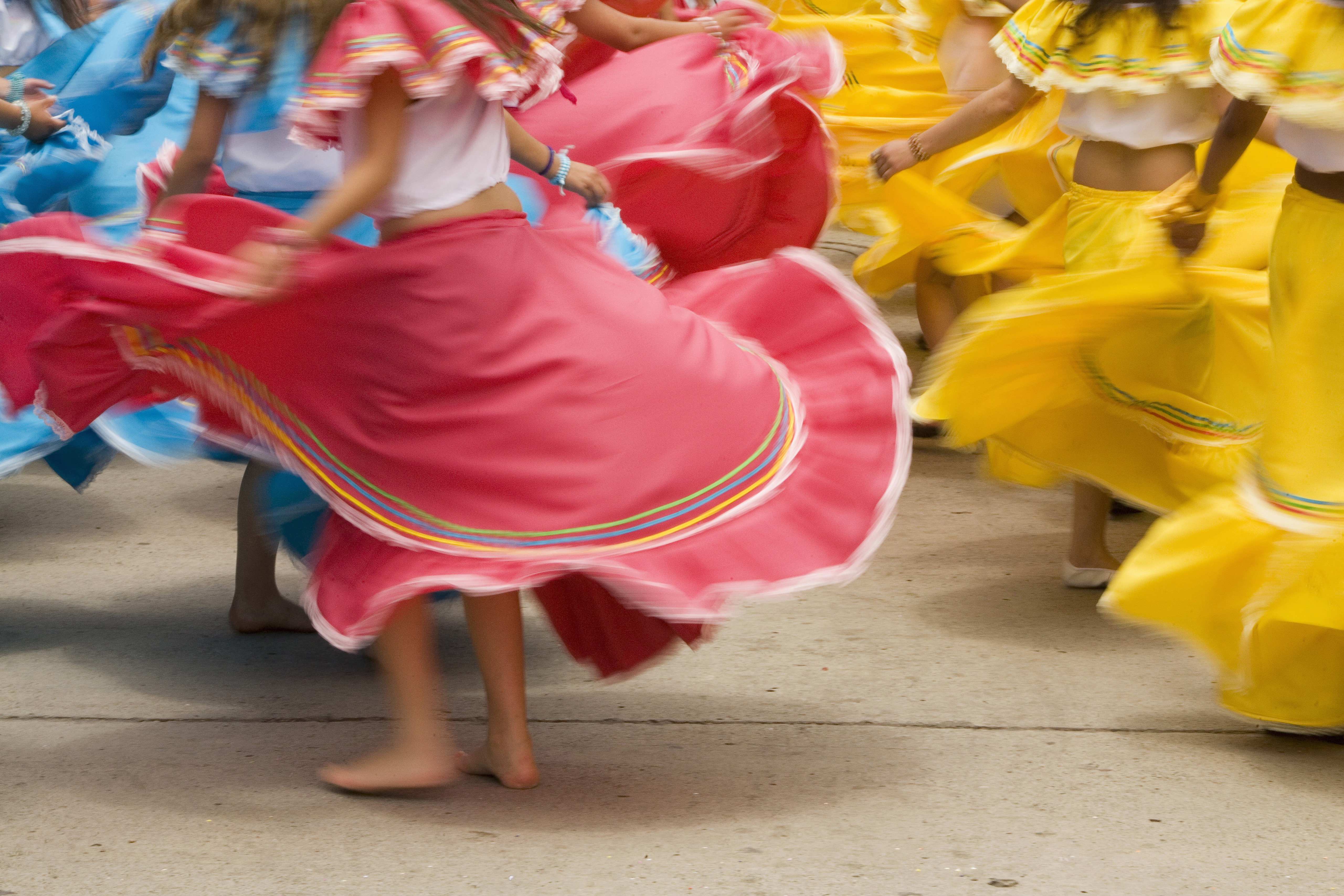 Dancers in colorful skirts spin, creating bright swirls of fabric.