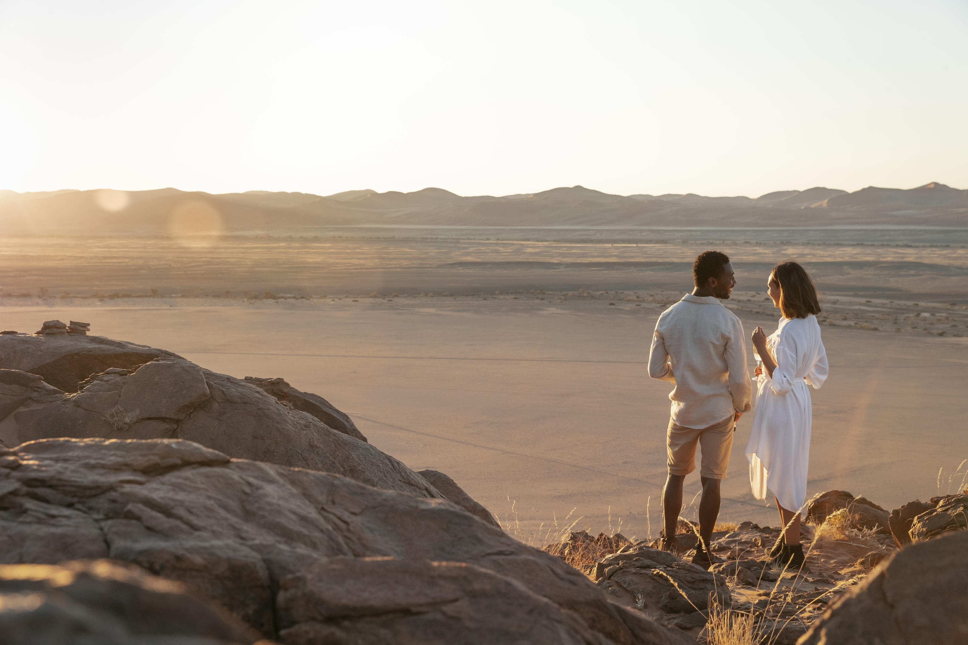 two people watch sunset in the Namibian desert
