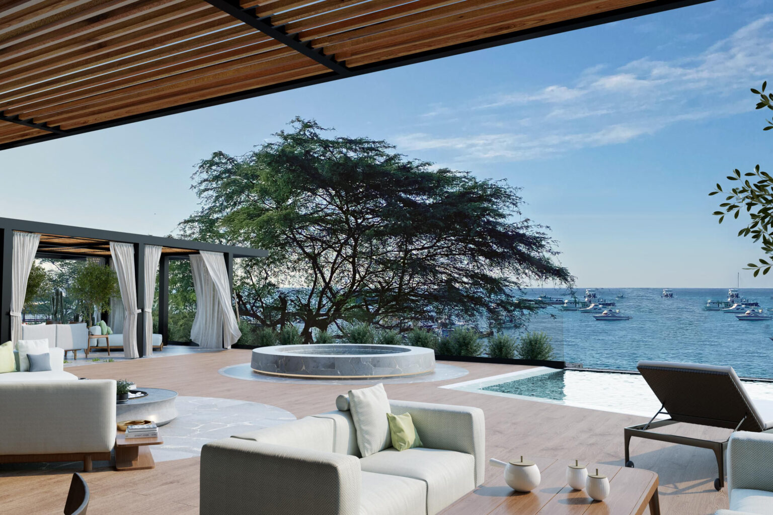 Modern terrace lounge with white sofas beside an infinity pool, looking out over calm ocean and anchored boats.