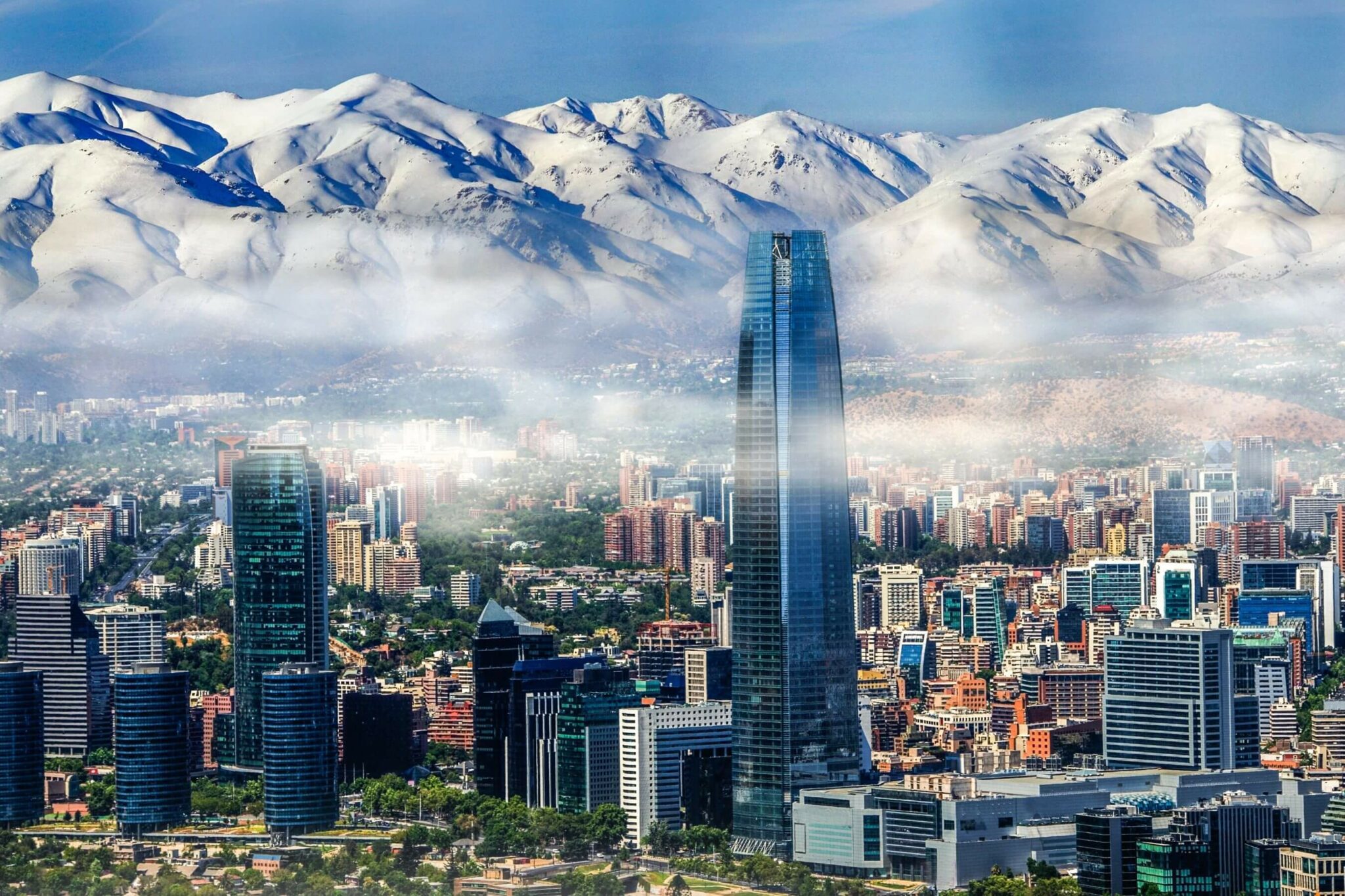 Santiago’s skyline stretches toward the Andes, with the tallest tower rising above the city under clear air.