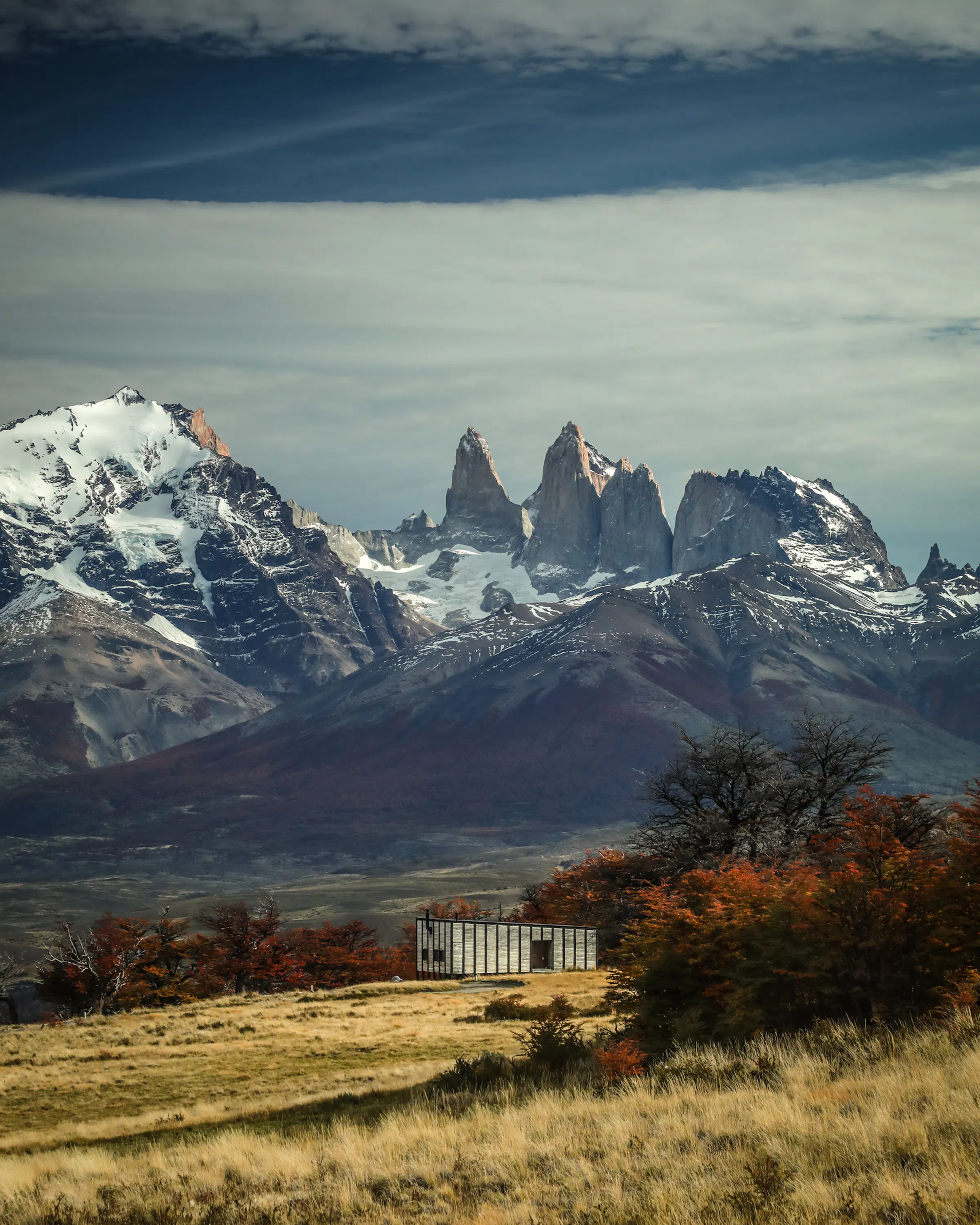 Awasi villas sit on open steppe, each facing the Torres del Paine skyline beneath sweeping cloud cover, in Patagonia..