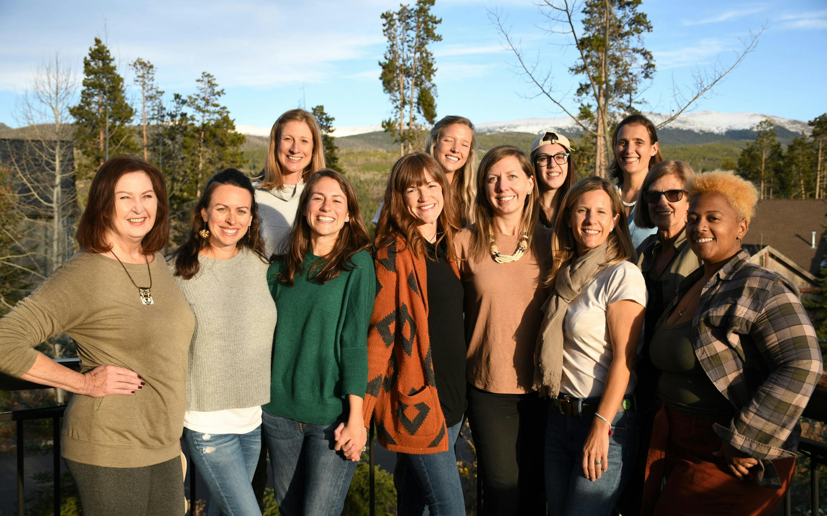A group of 10 smiling women standing outdoors.