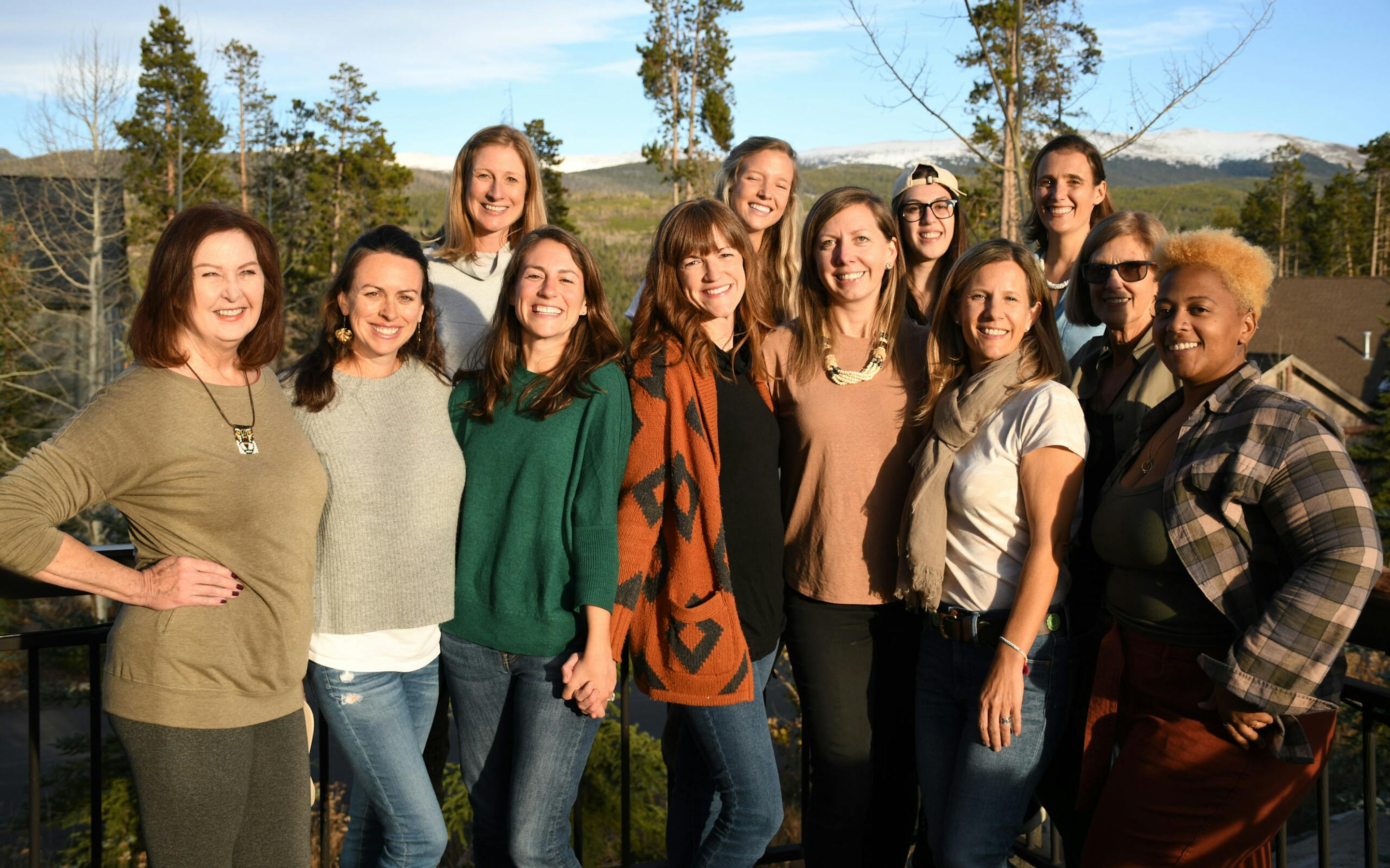 A group of 10 smiling women standing outdoors.
