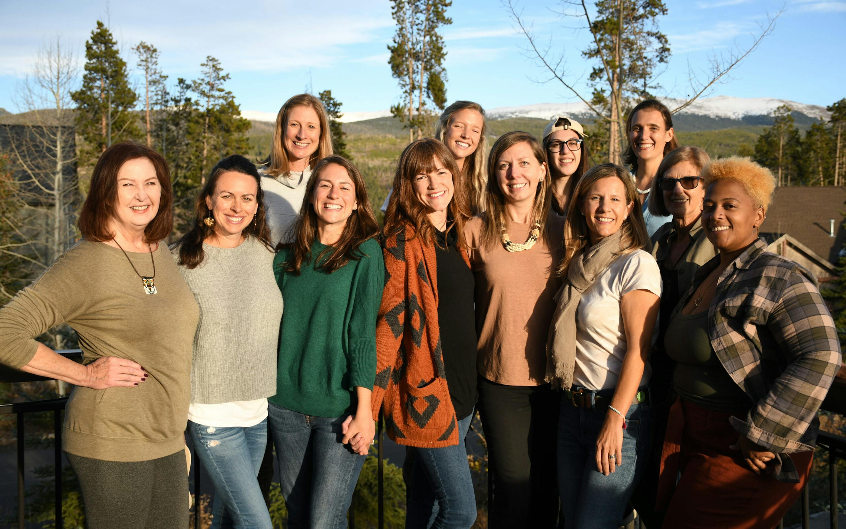 A group of 10 smiling women standing outdoors.