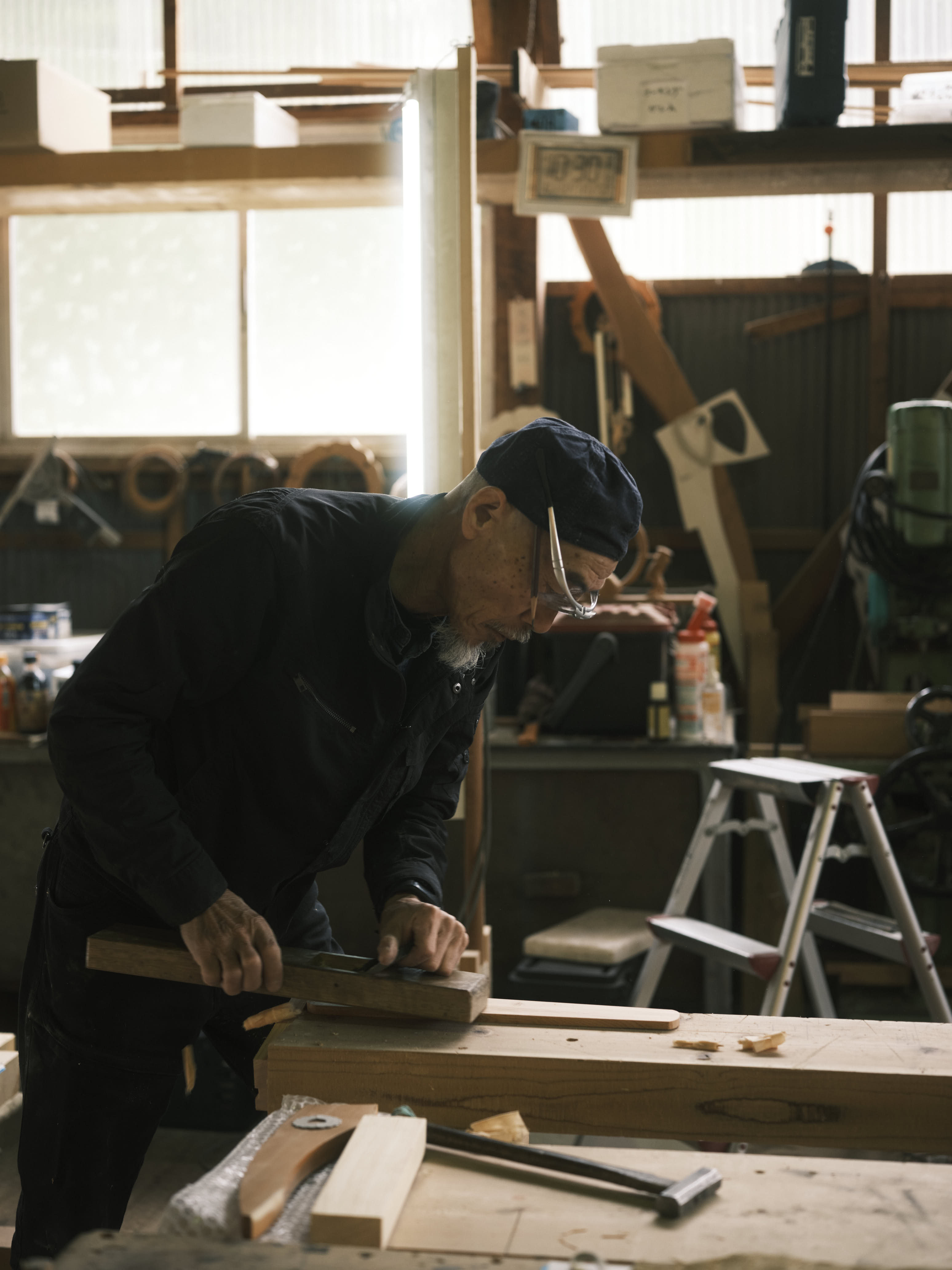 A carpenter carves wood at a workbench during a guided workshop at Kusakabe Folk Crafts Museum in Takayama.
