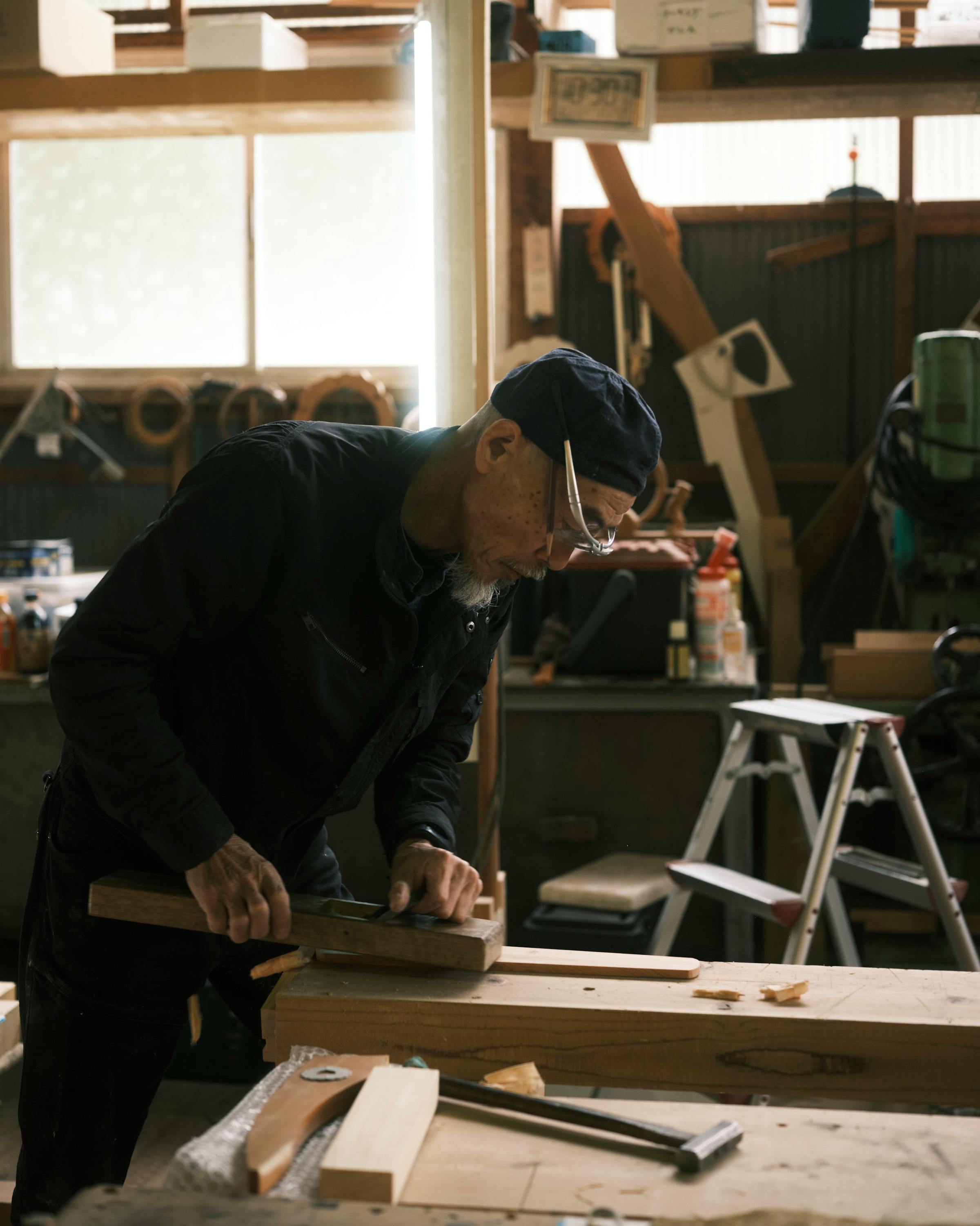 A carpenter carves wood at a workbench during a guided workshop at Kusakabe Folk Crafts Museum in Takayama.