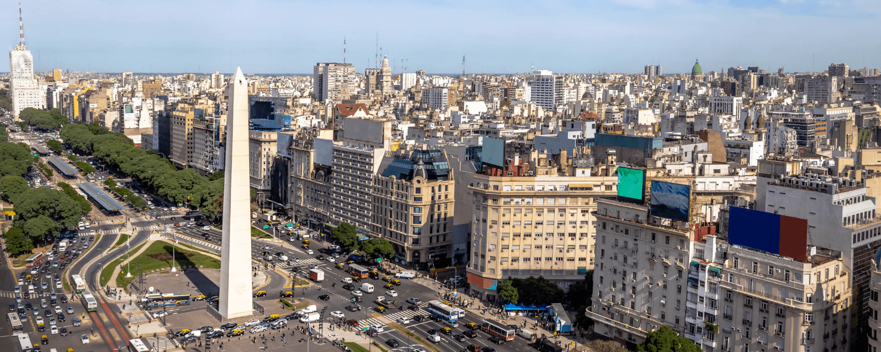 The Obelisk and broad lanes of 9 de Julio Avenue cut through central Buenos Aires beneath a clear morning sky.