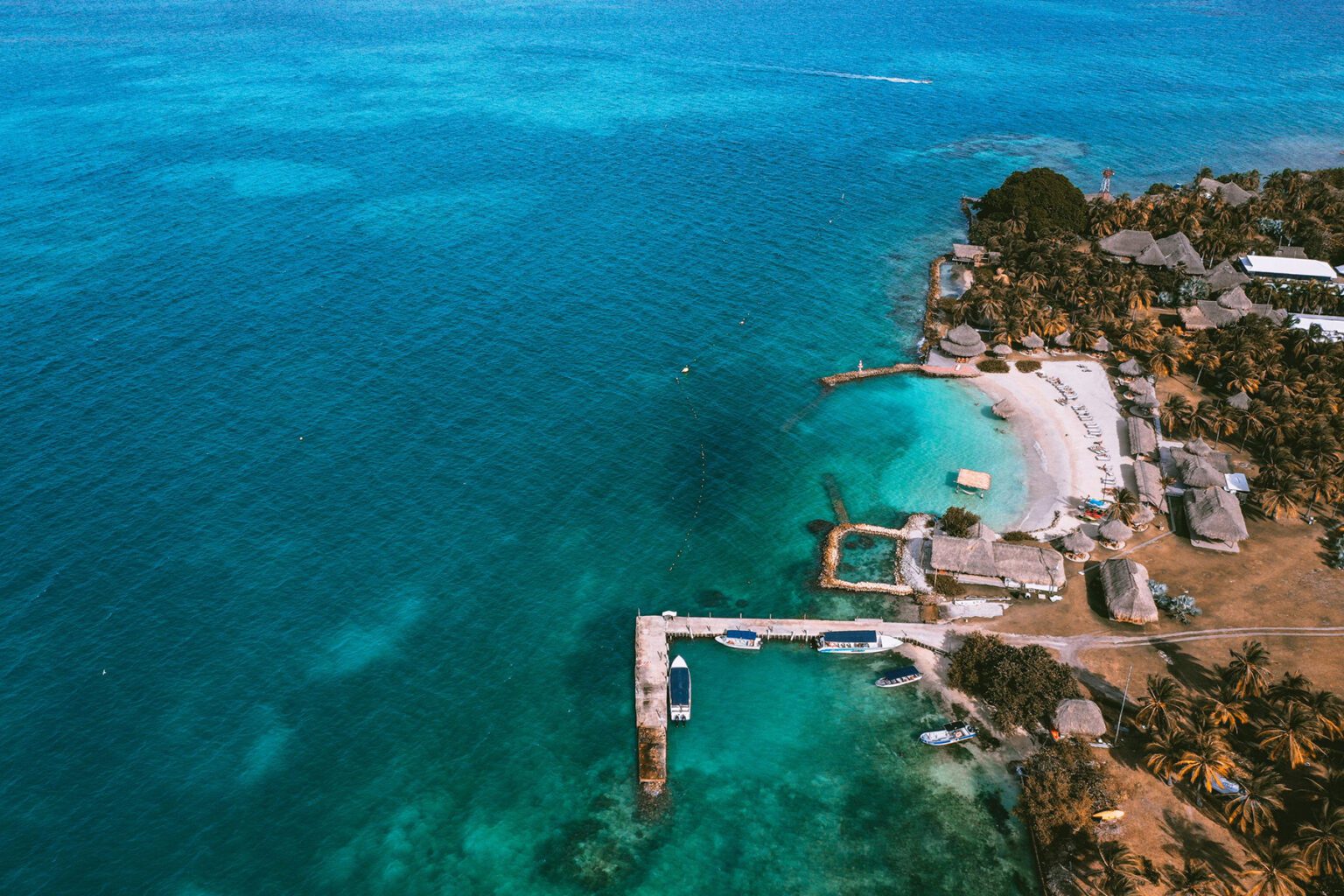An aerial view reveals bright shallows, white sand, and a secluded lodge on Colombia's Islas San Bernardo.