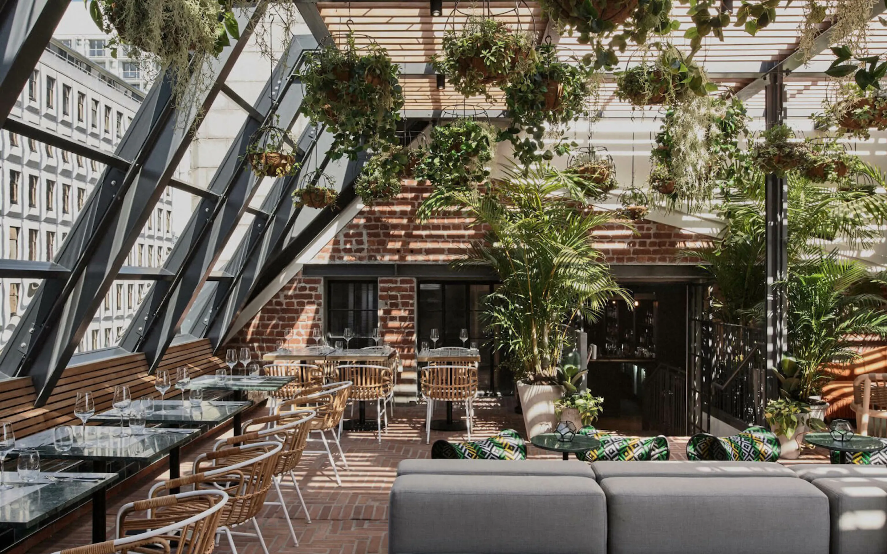 A lush rooftop lounge filled with plants and seating at Gigi Rooftop in Cape Town.
