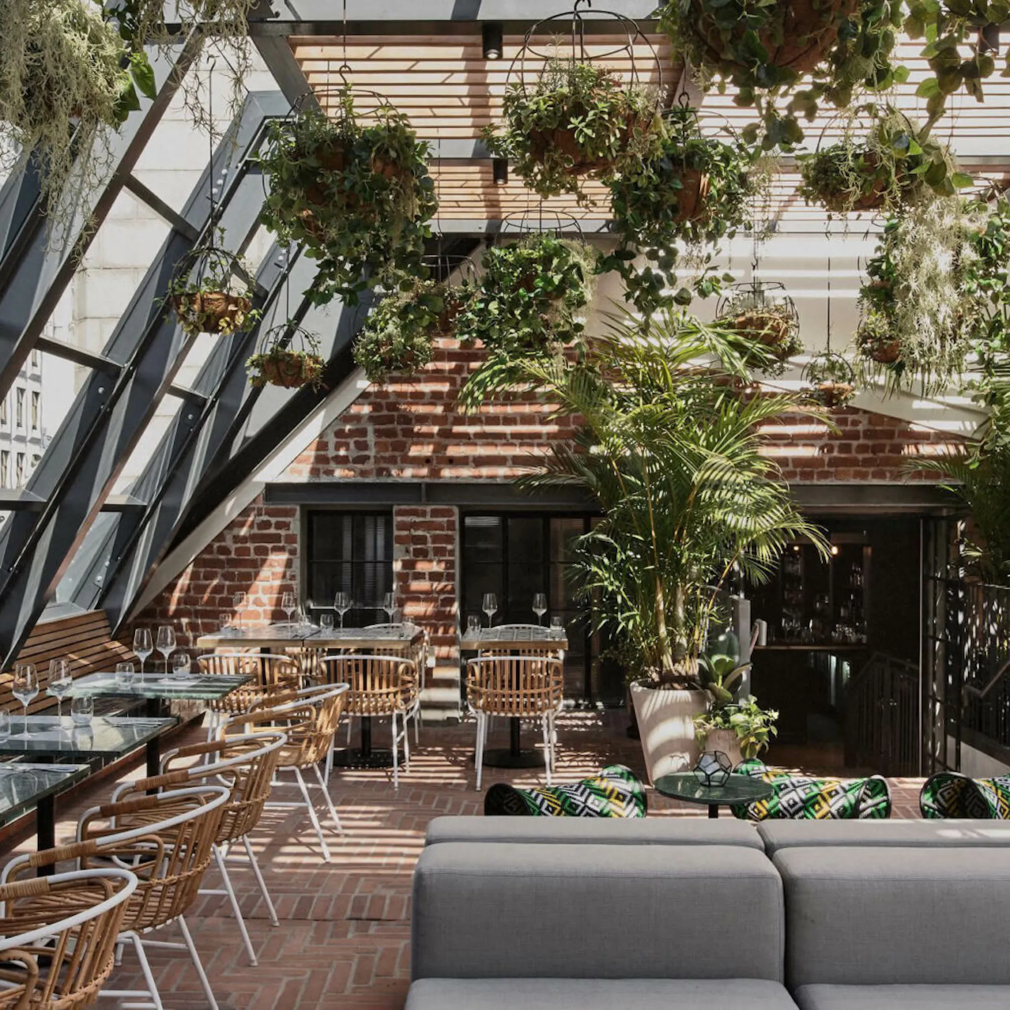 A lush rooftop lounge filled with plants and seating at Gigi Rooftop in Cape Town.