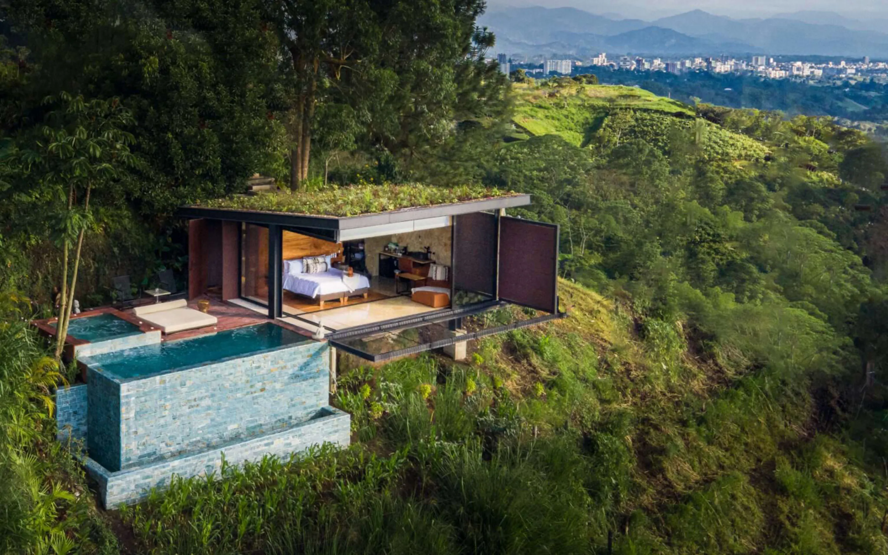A mountain lodge with a plunge pool above green hills at Bio Habitat Hotel, set in near Medellin, Colombia.