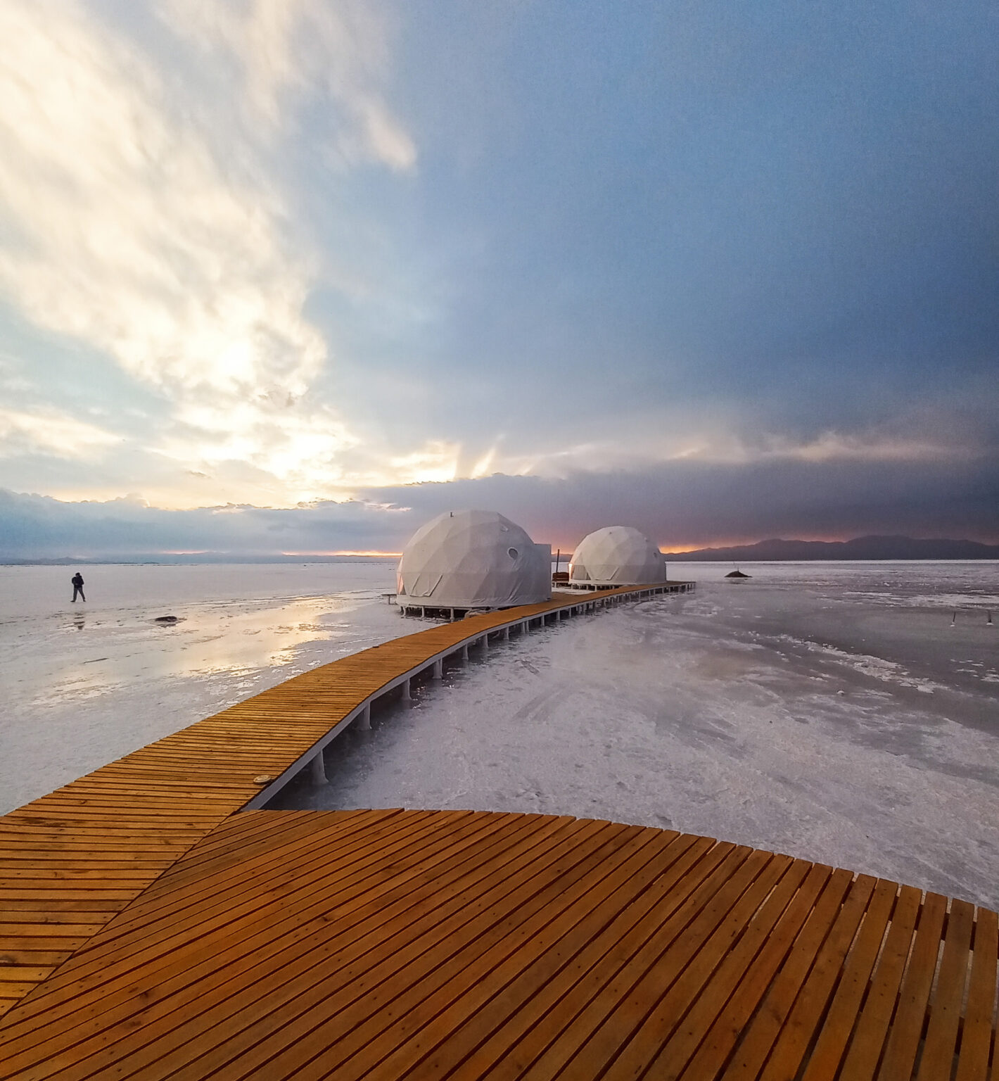 Domed cabins set beside white salt flats and desert hills at Domos de Salinas, set in northwest Argentina.
