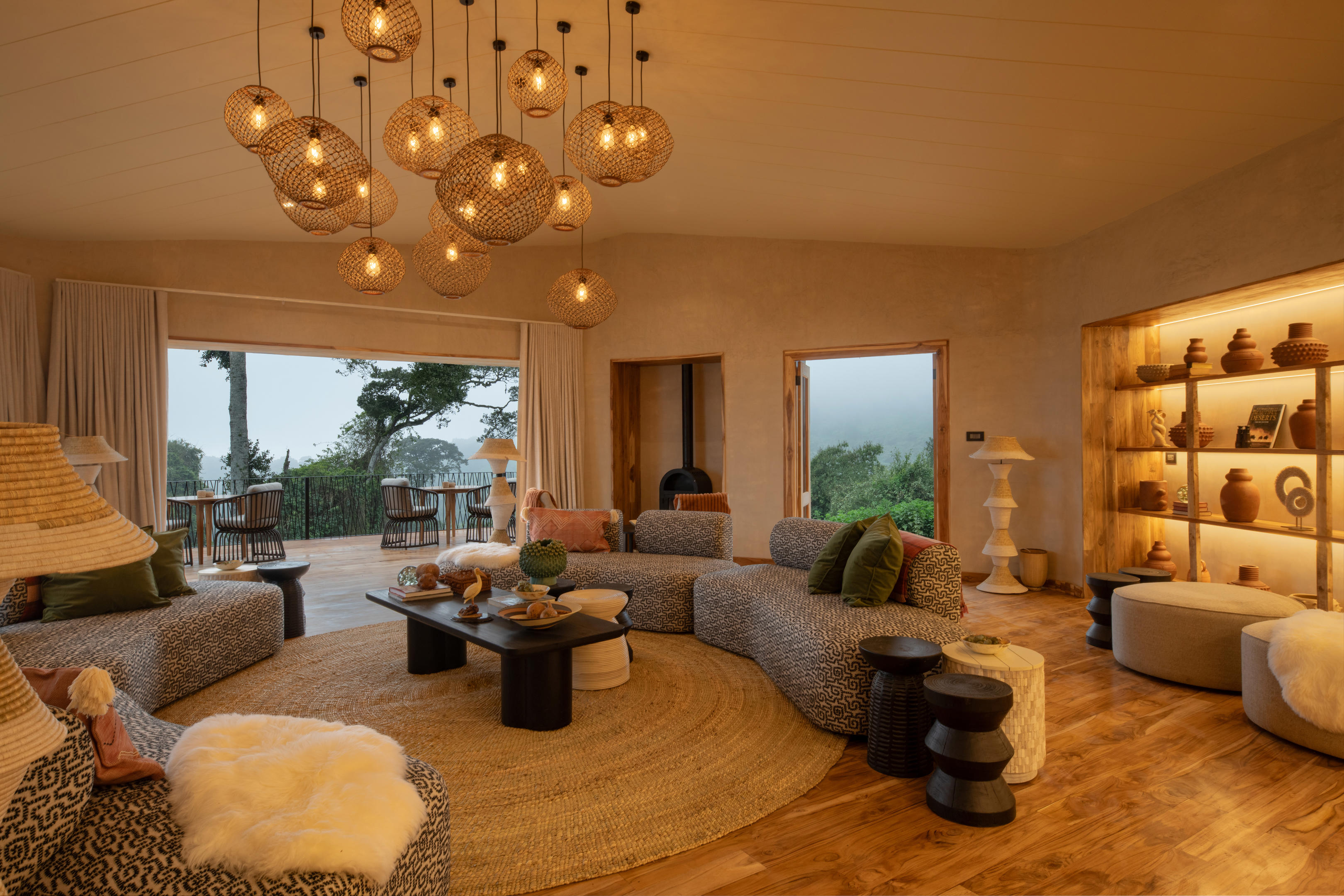 A circular lounge at Lemala Osonjoi glows warmly, with woven lights, deep sofas, and wide windows to the hills.