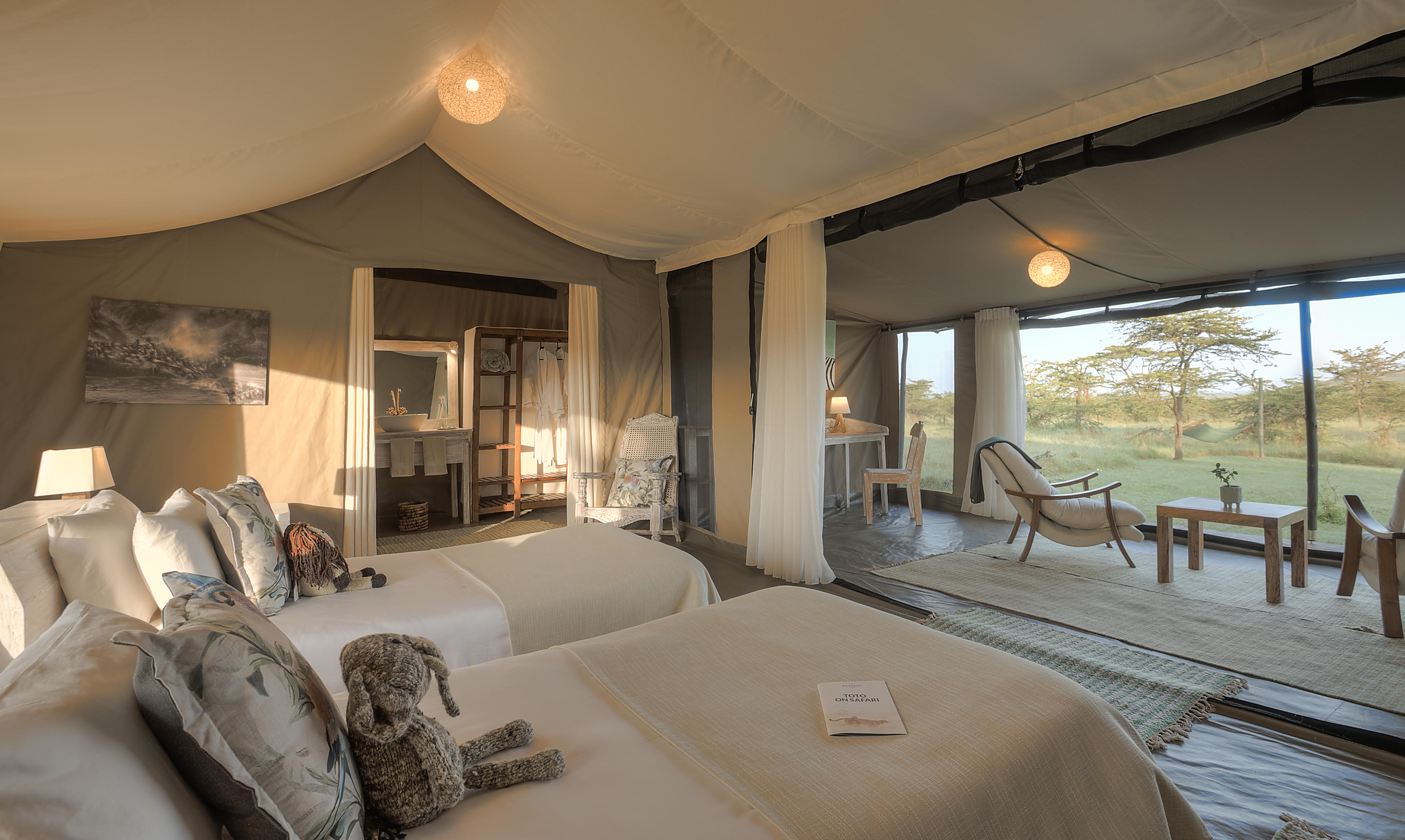 A family suite at Kicheche Bush Camp opens onto a deck, with twin beds and views across the grassland beyond.