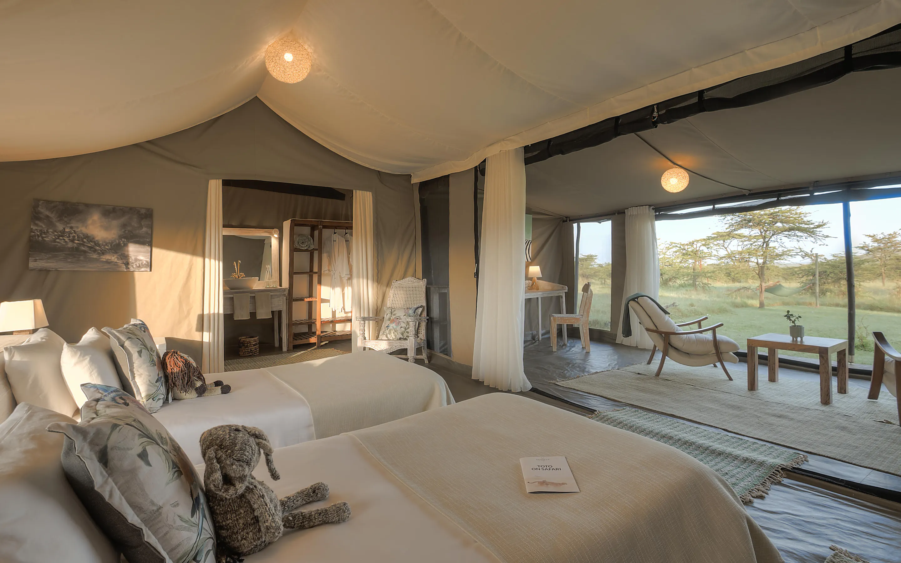 A family suite at Kicheche Bush Camp opens onto a deck, with twin beds and views across the grassland beyond.