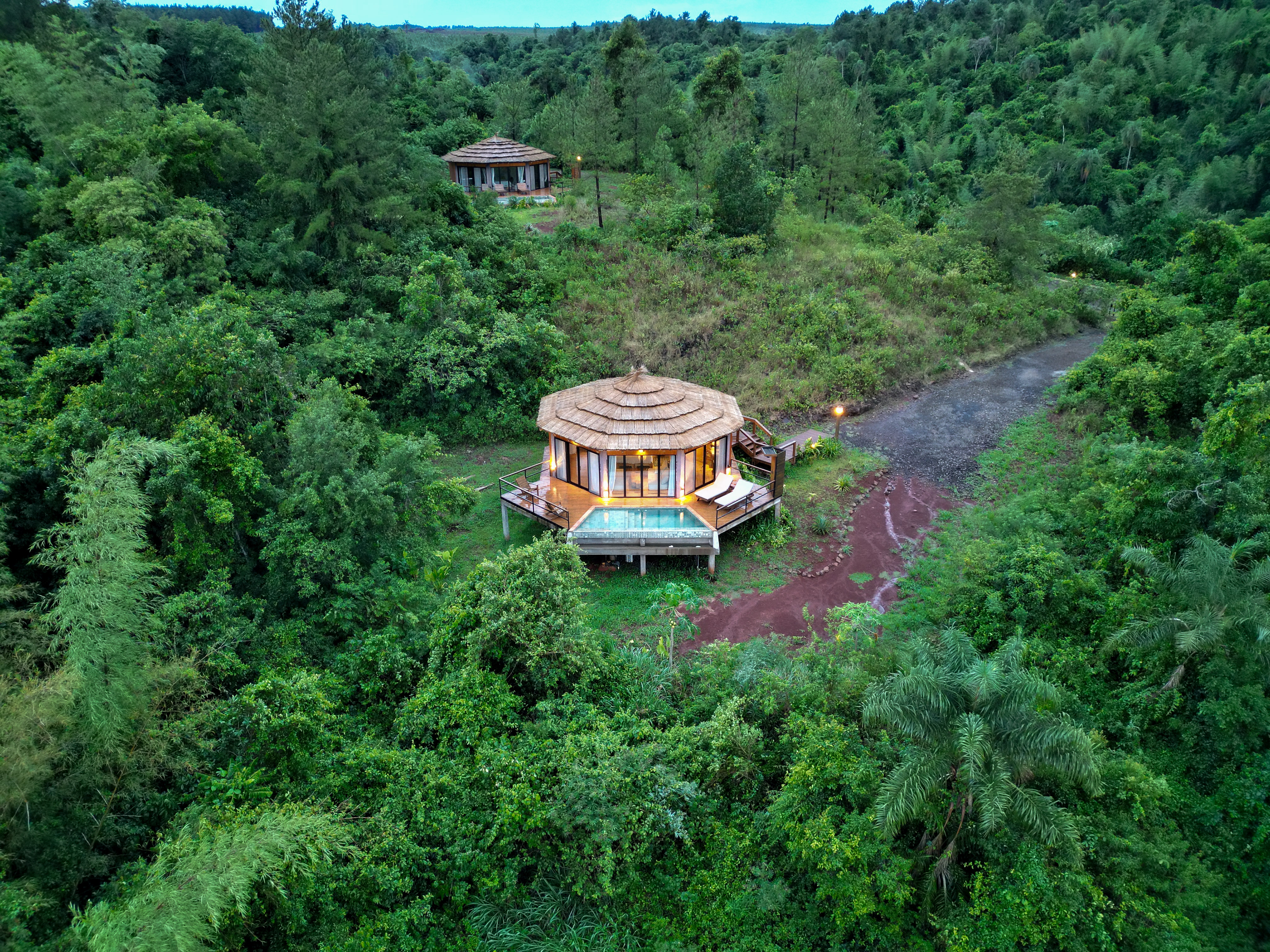 An aerial view shows round tented suites and forest paths tucked into dense green jungle at Pristine Iguazu.