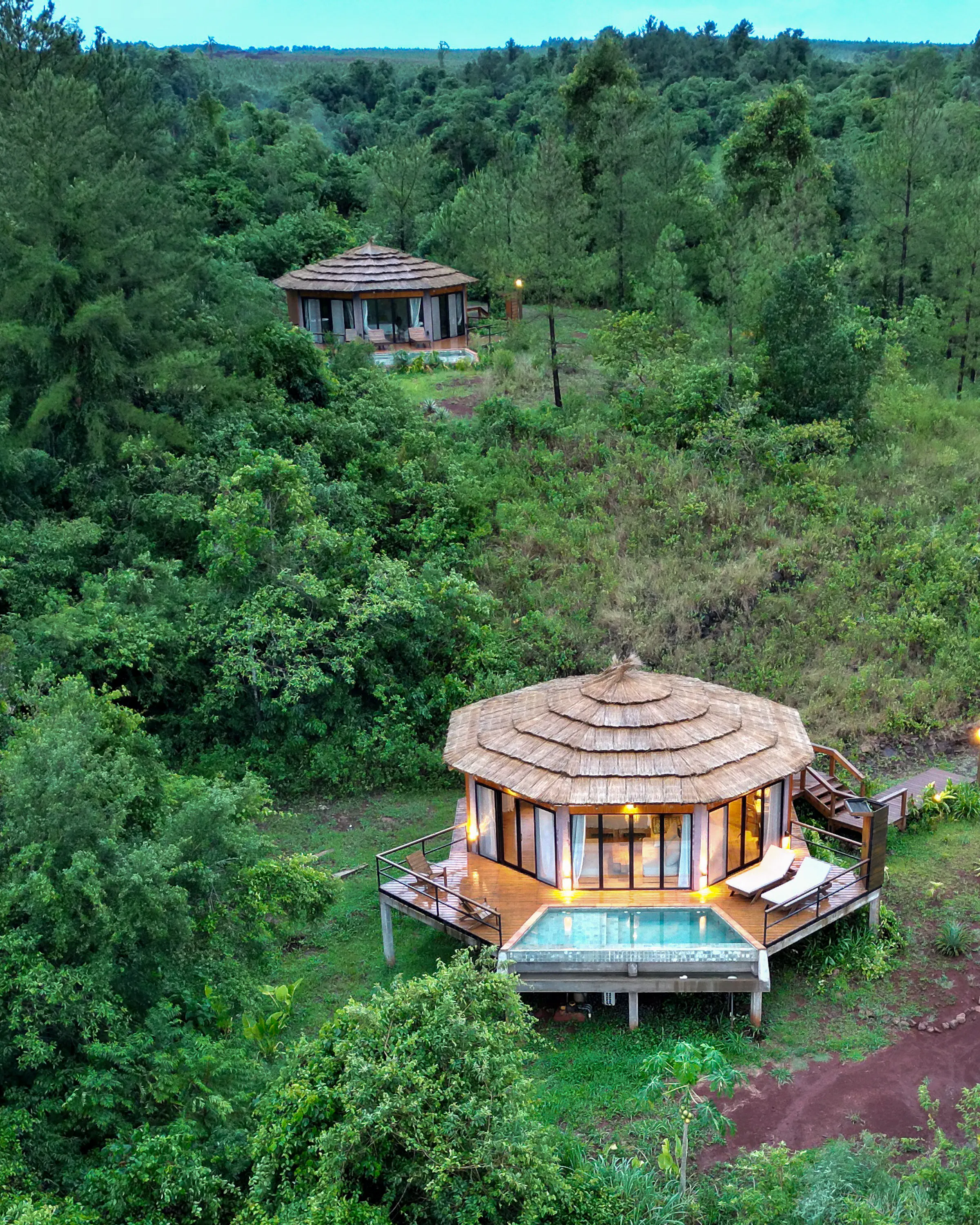 An aerial view shows round tented suites and forest paths tucked into dense green jungle at Pristine Iguazu.