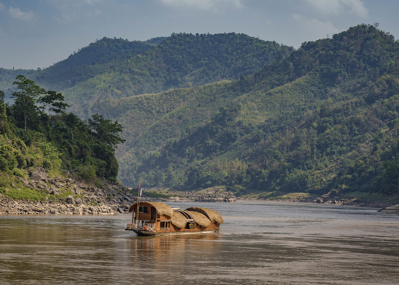 a house boat floats down a river