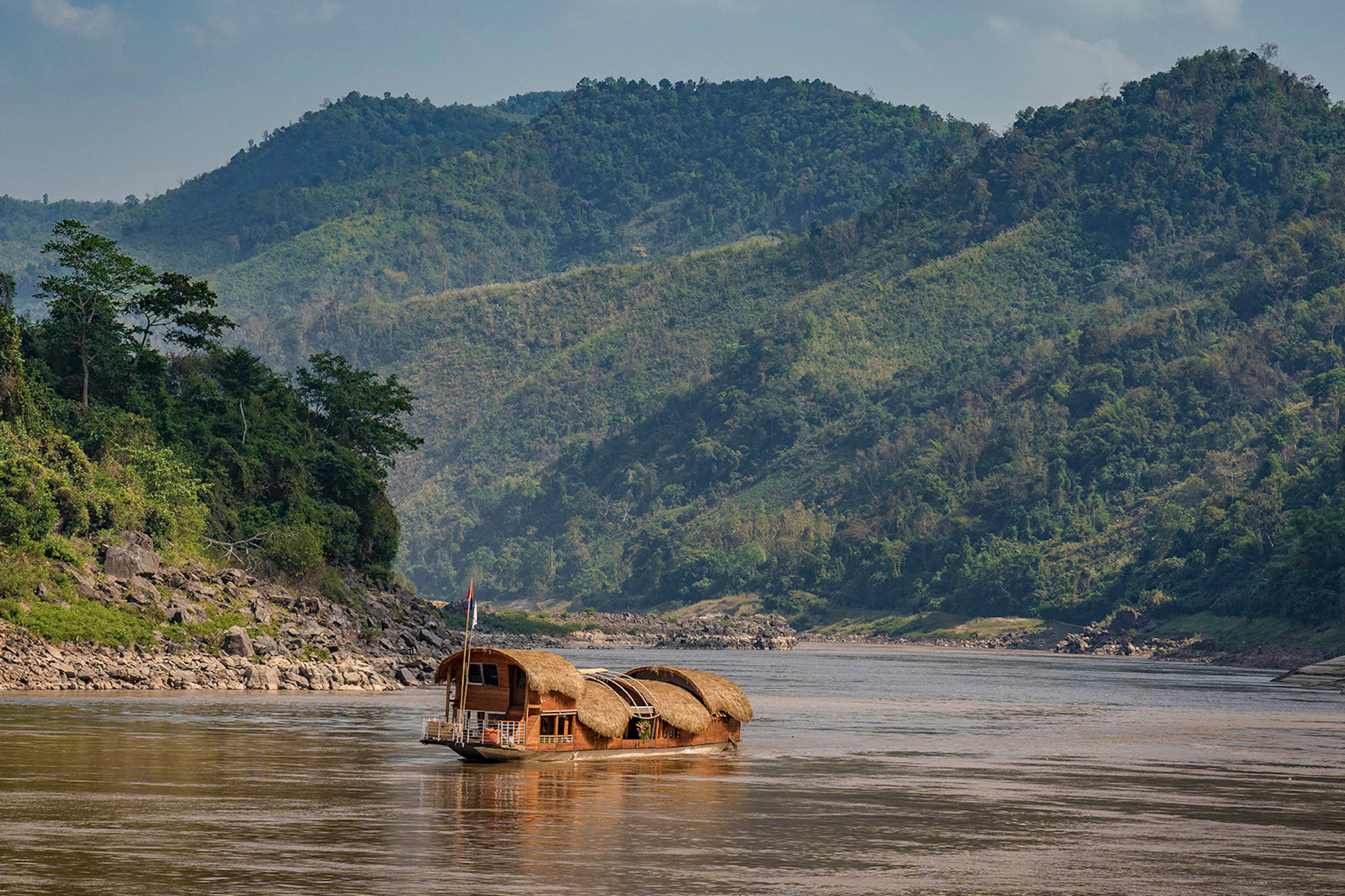 a house boat floats down a river