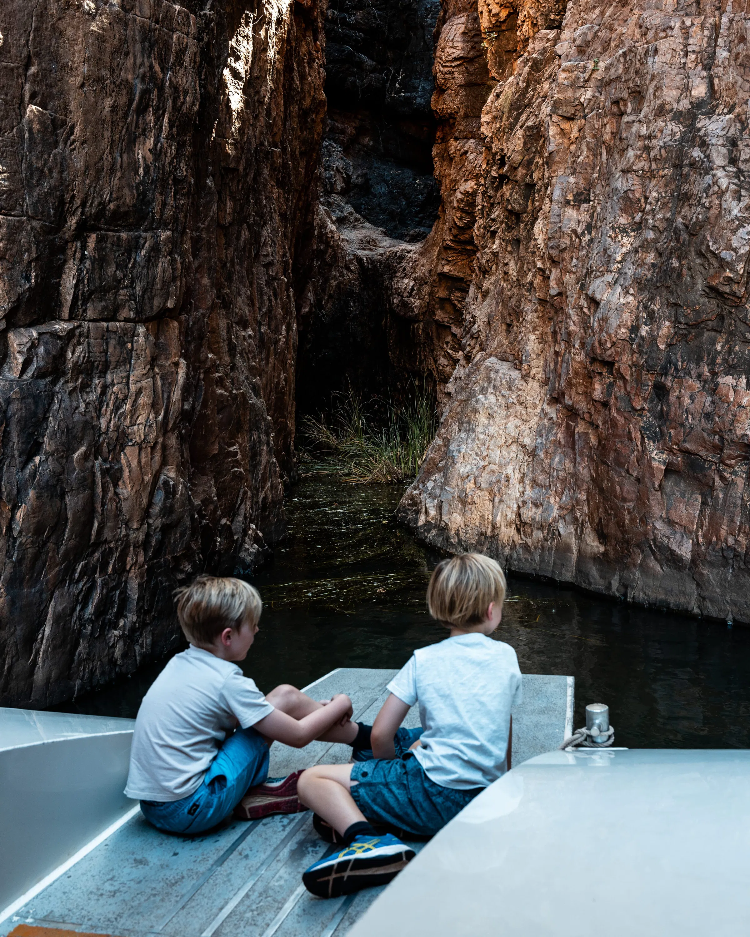 children on boat in a cave