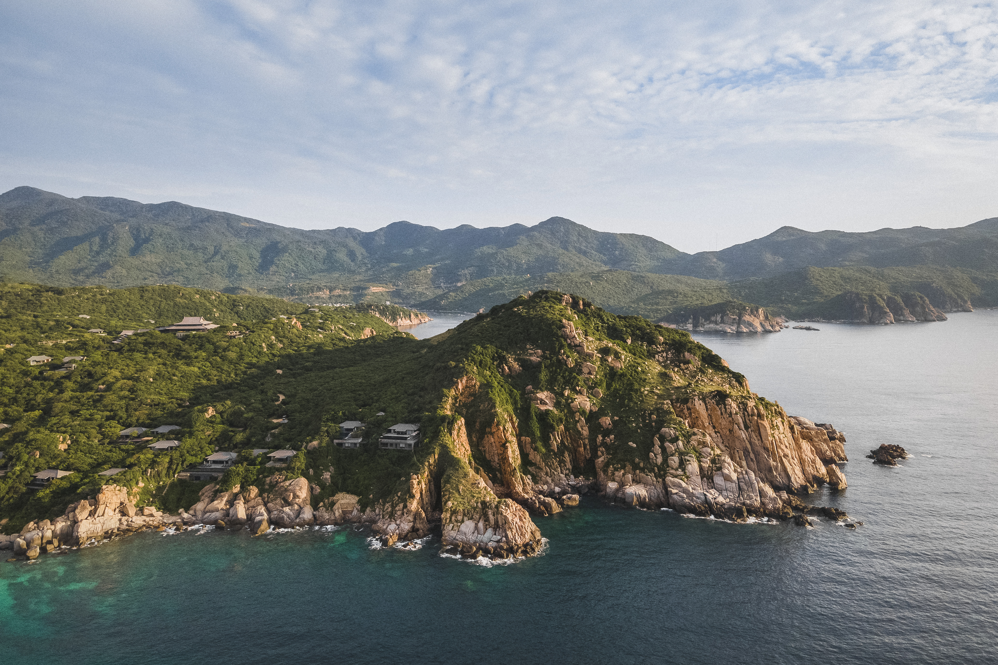 An aerial view shows Amanoi villas set among rocky green hills above a calm bay on Vietnam's south-central coast.