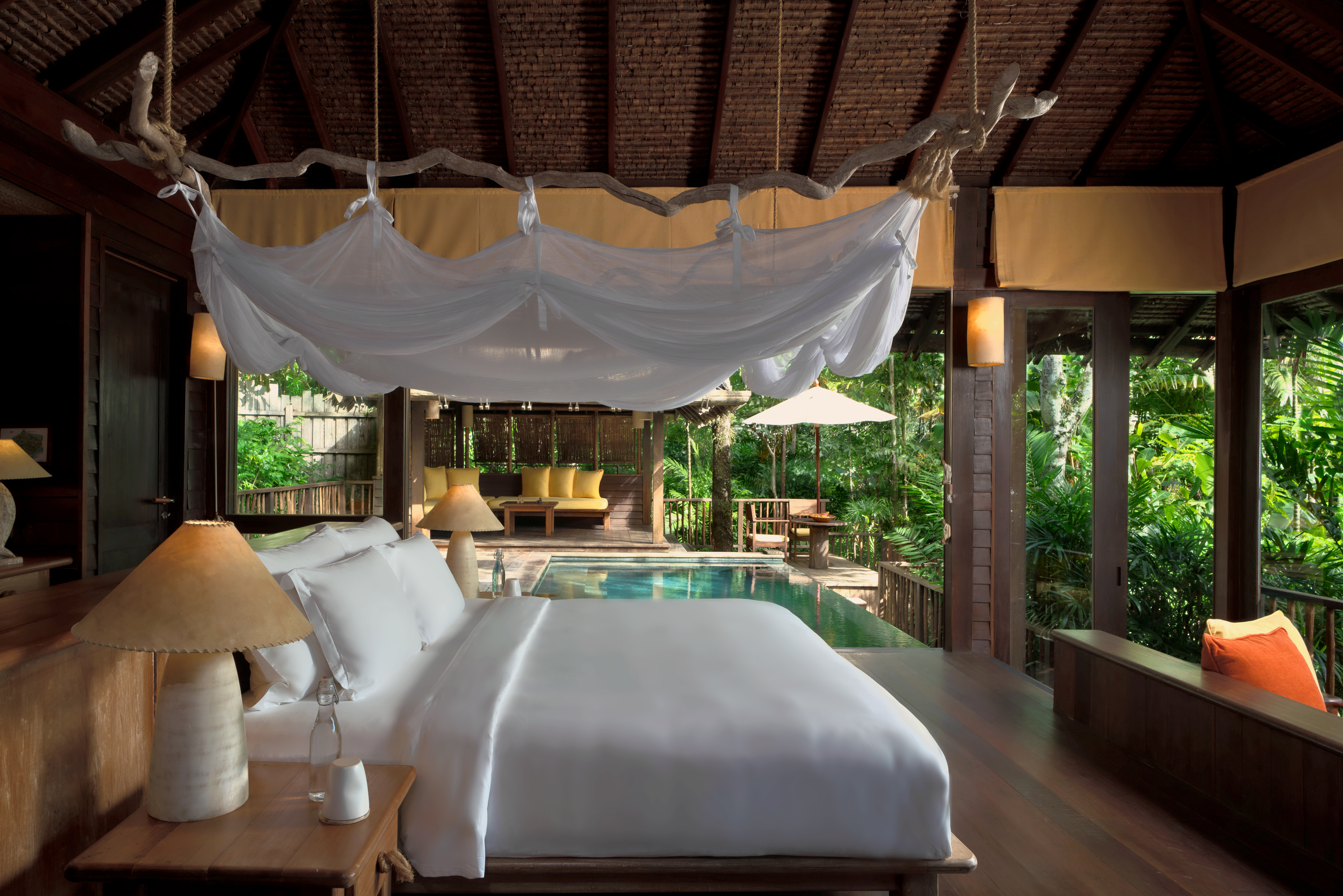 A bed faces a private pool and tropical greenery inside a Hideaway Pool Villa at Six Senses Yao Noi.