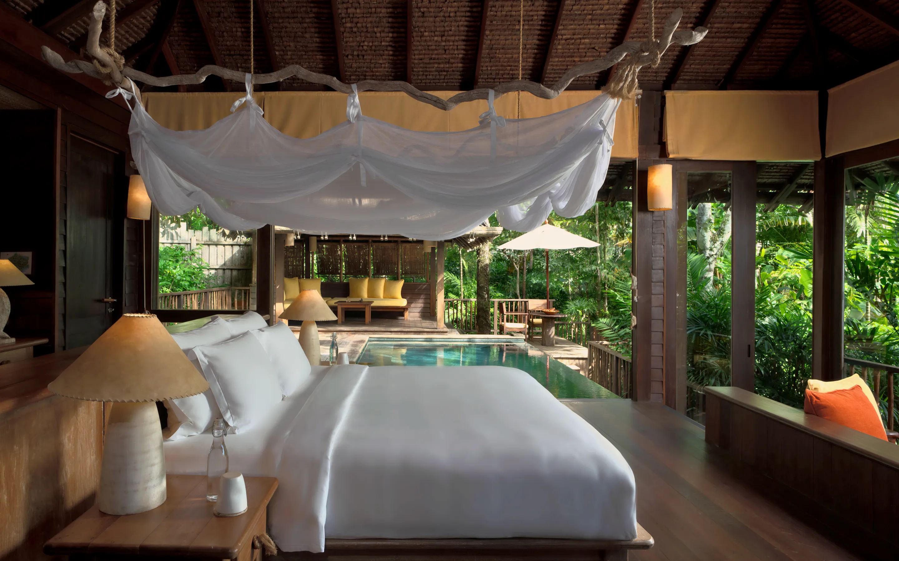 A bed faces a private pool and tropical greenery inside a Hideaway Pool Villa at Six Senses Yao Noi.