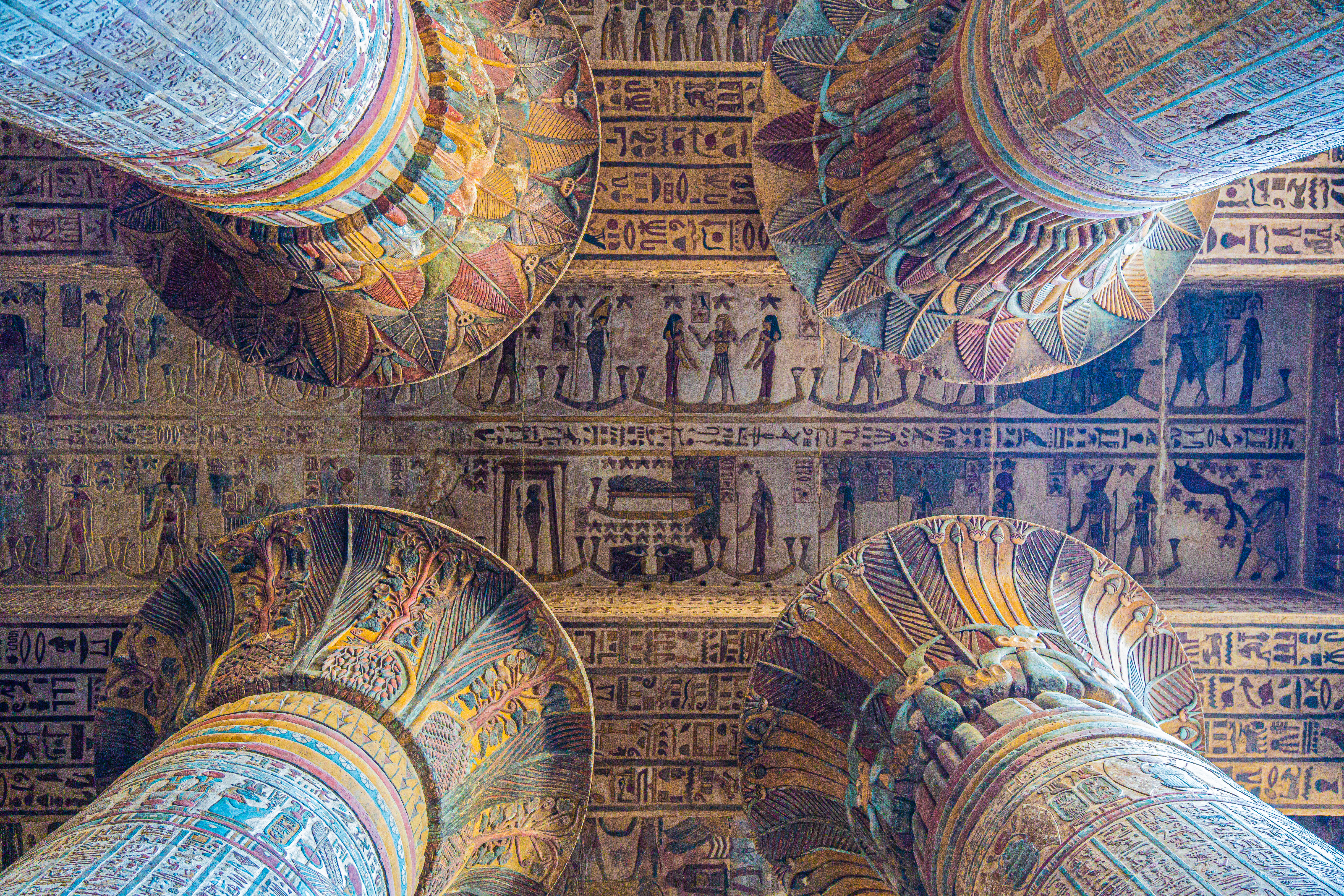 Painted columns and carved reliefs cover the ceiling and walls of Kom Ombo Temple in a close interior view.