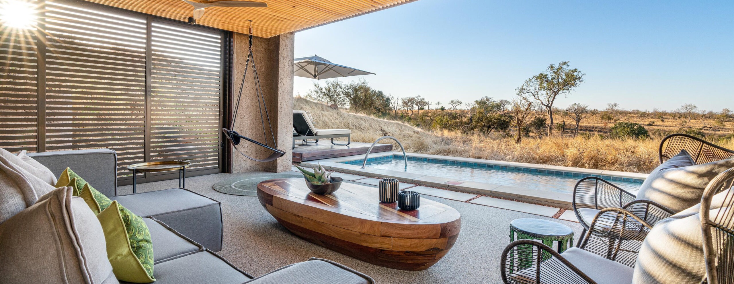 A lounge deck with plunge pool faces dry bushland from a luxury suite at Sabi Sabi Earth Lodge in South Africa.