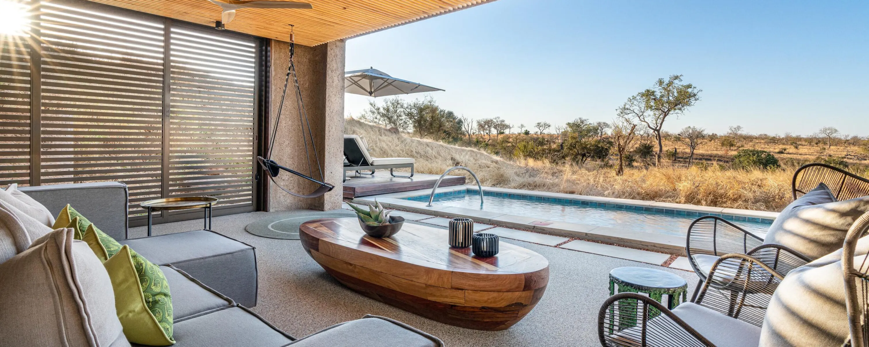 A lounge deck with plunge pool faces dry bushland from a luxury suite at Sabi Sabi Earth Lodge in South Africa.