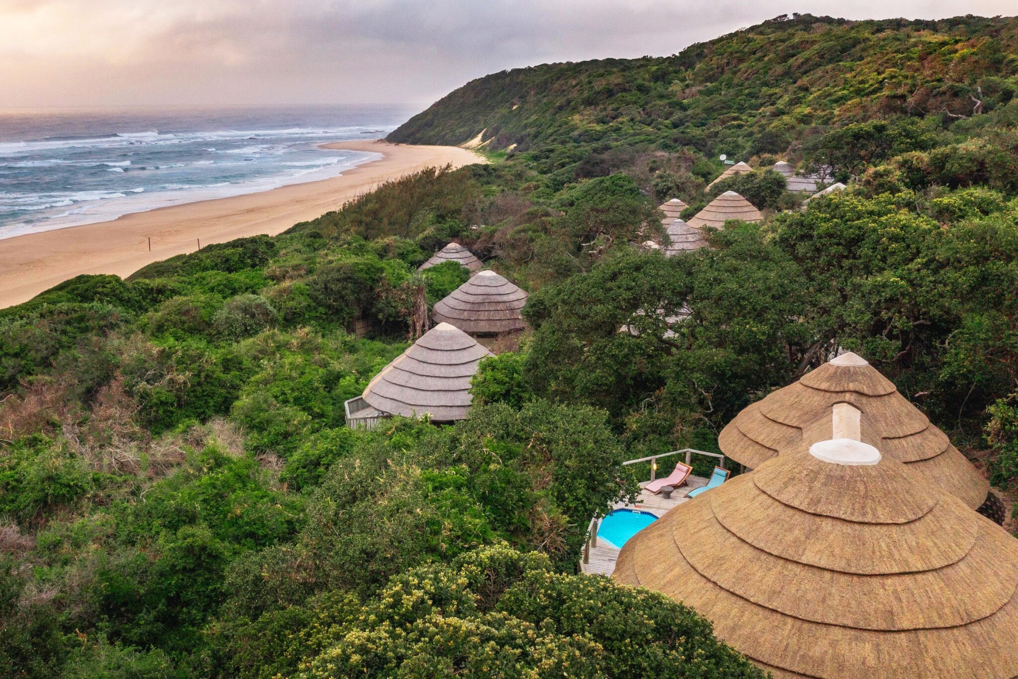 Thatched suites nestle in coastal forest above a long sandy beach at Thonga Beach Lodge in KwaZulu-Natal, South Africa.
